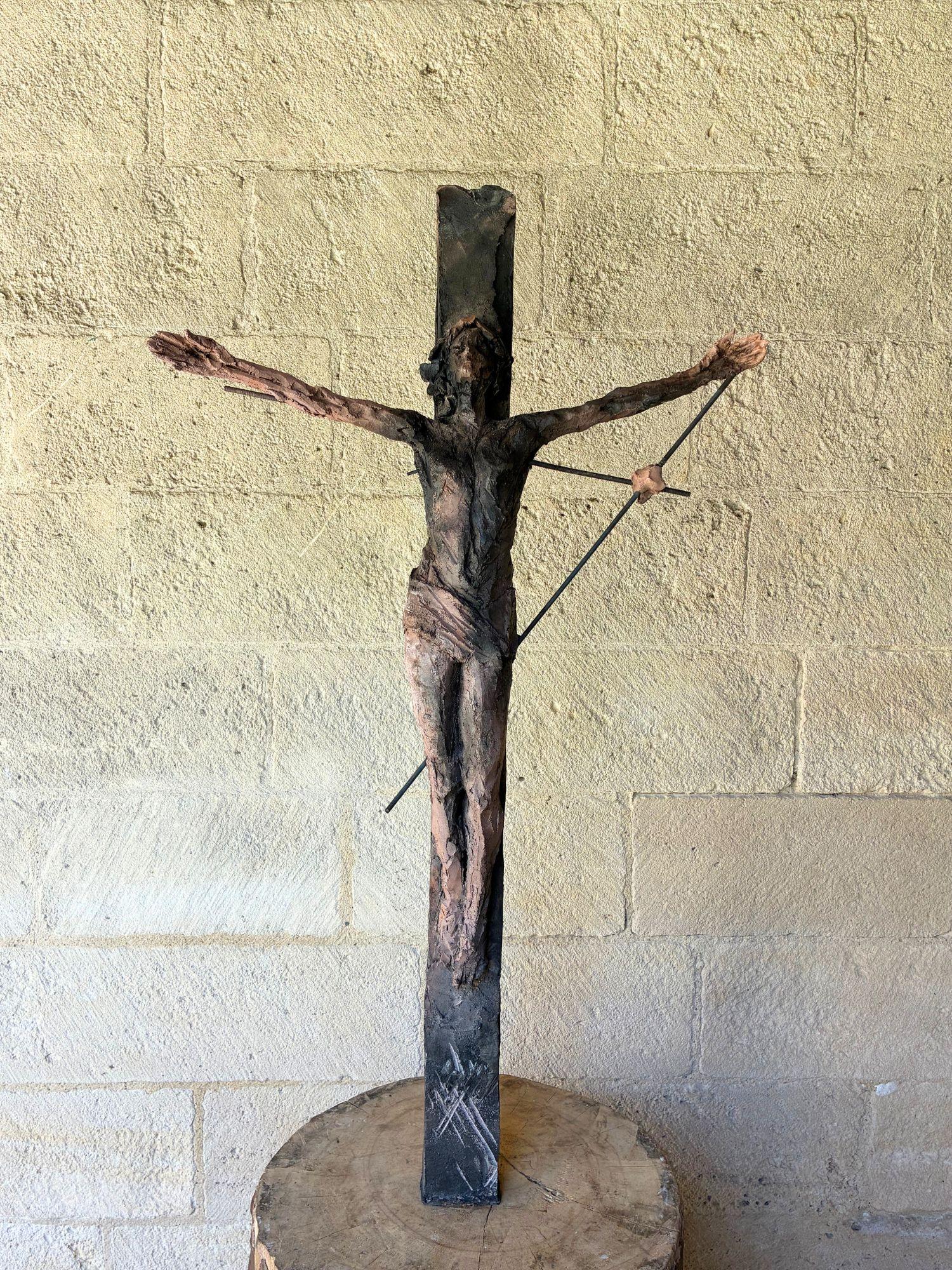 Un Cristo es una escultura única de gres cocido al humo, obra de la artista contemporánea francesa Cécile Raynal. Sus dimensiones son 174 × 53 × 35 cm. Las dimensiones incluyen la base de madera (mesa de madera).
Esta escultura es una pieza única