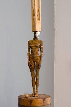Balancing Act, bronze and wood sculpture of female with head accessory