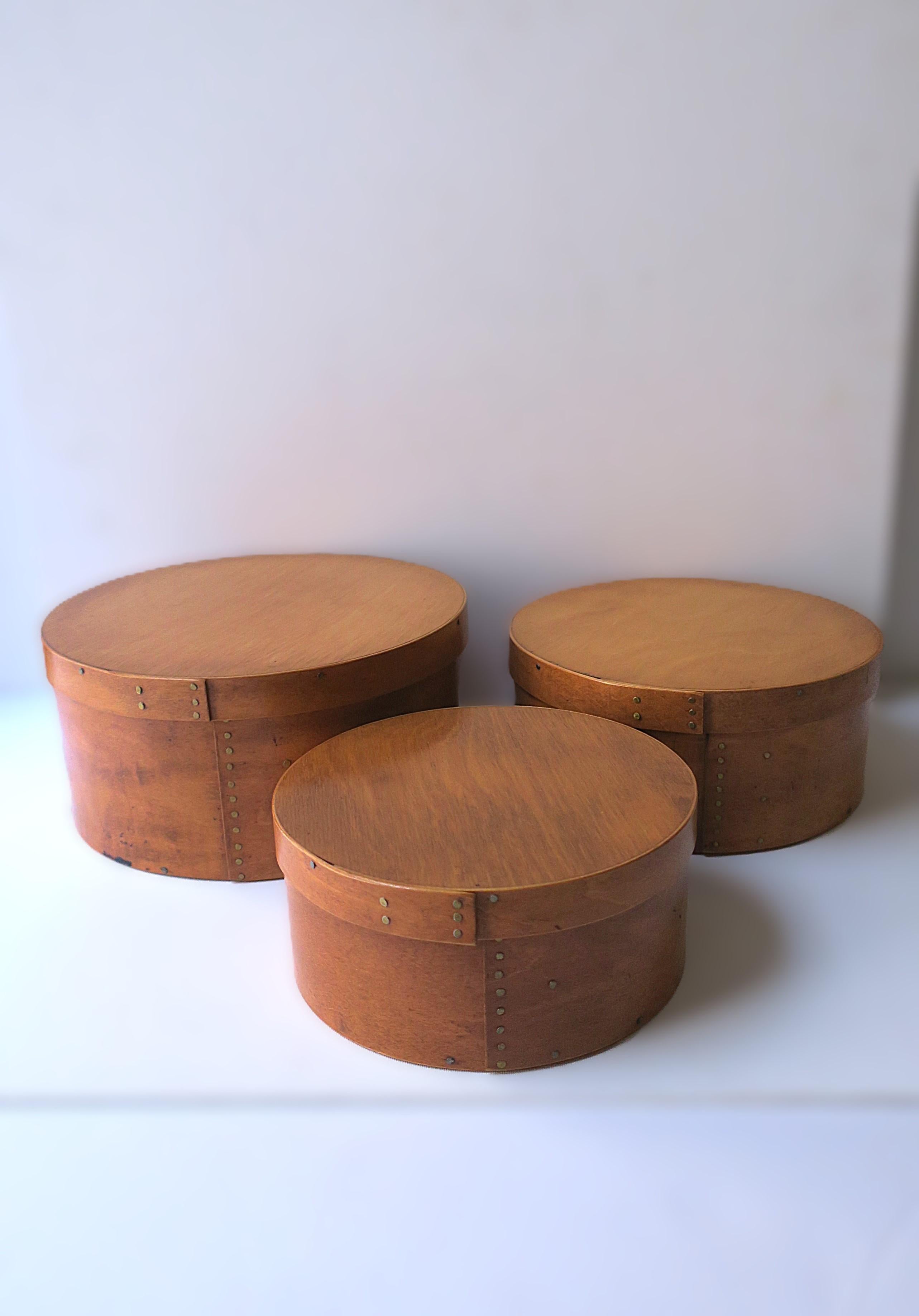 A beautiful set of three (3) finely crafted bentwood cedar Shaker style (nesting) storage or decorative boxes, circa late-20th century, American. Boxes, each made of beautiful, grained cedar wood and tacked with hand forged brass nails. A great set