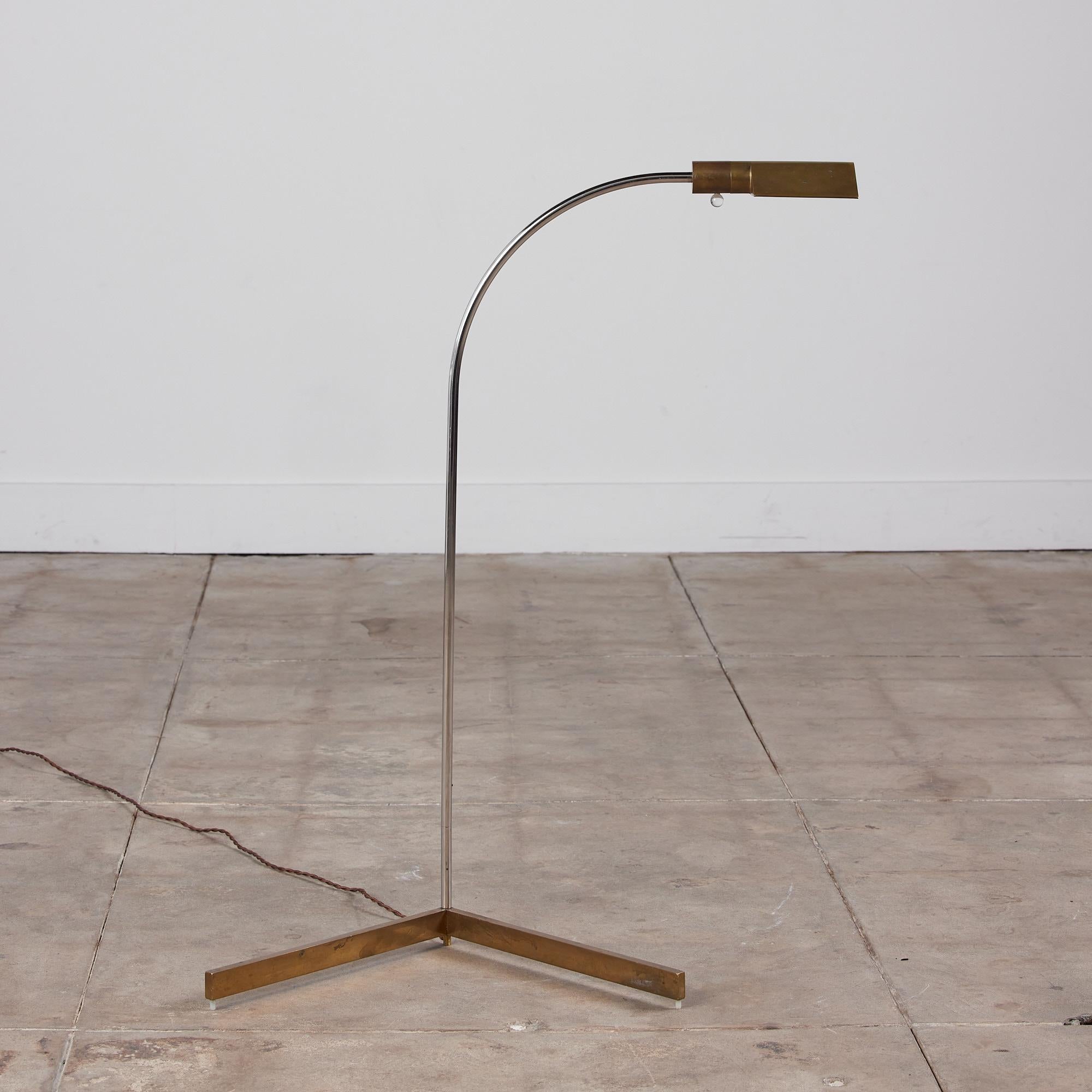 Designed in the 1970s, the brass floor lamps by Cedric Hartman are an enduring design Classic. The modernist floor lamp features a triangular brass shade attached to a curved stem that offers focused task lighting. The arched chrome pole terminates