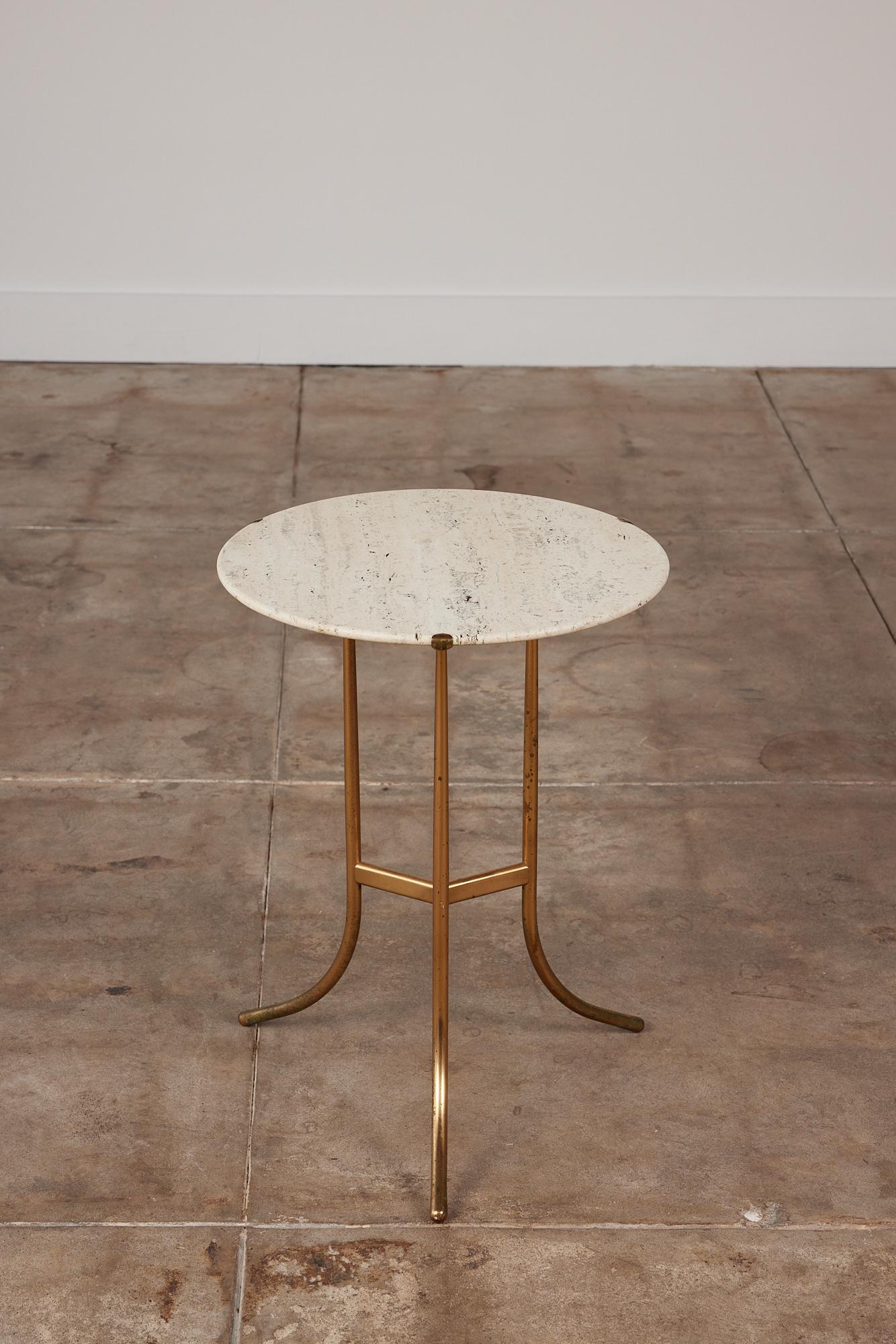 Cedric Hartman brass and travertine side table c. 1970s, USA. A round travertine stone top rests inside three delicate brass prongs. The table features a pedestal base with three splayed legs, minimal yet elegant.

Dimensions: 17