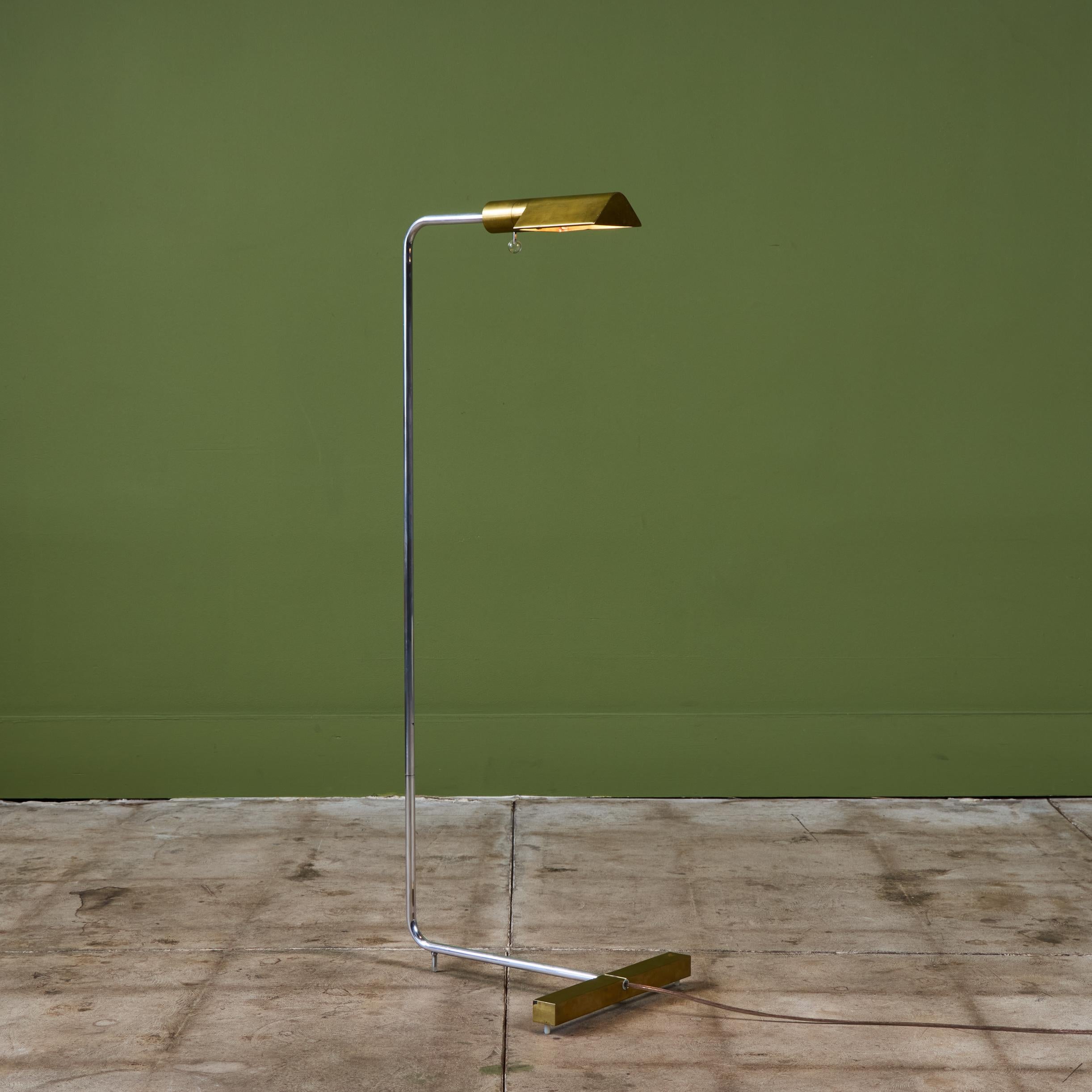 Progettata negli anni '70, questa lampada da terra in ottone e acciaio inossidabile di Cedric Hartman è un classico del design. Questa lampada da terra modernista è caratterizzata da uno stretto paralume triangolare in ottone collegato a uno stelo