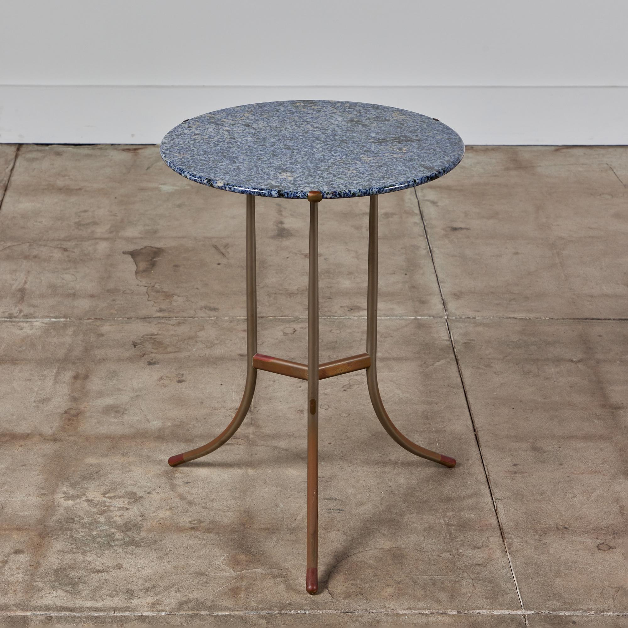 Cedric Hartman mixed metal and granite side table, circa.1970s, USA. The round striking blue granite stone table top showcases a cream and black veining. The table top rests inside three delicate copper prongs. The table features a pedestal base