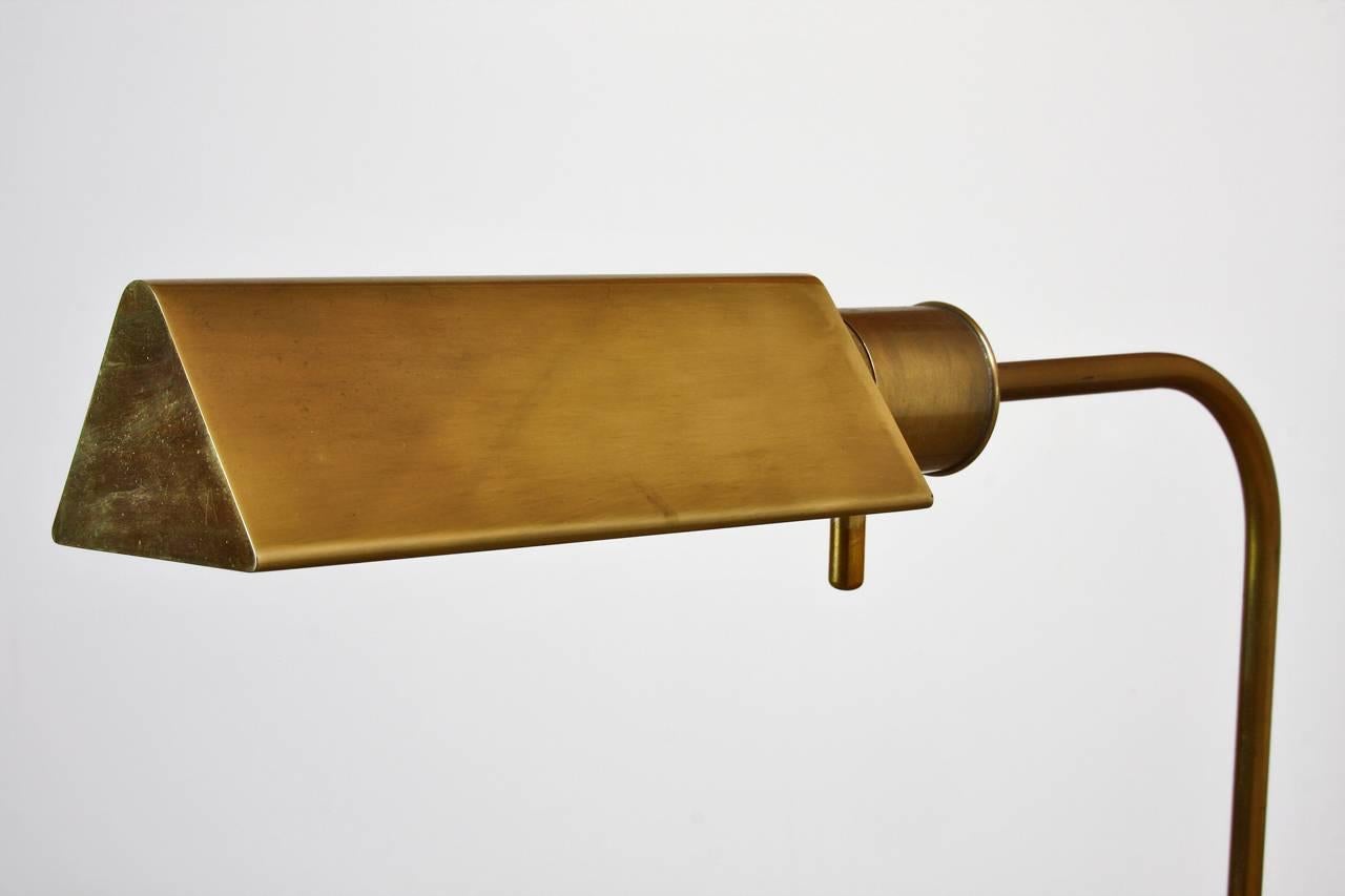 Midcentury brass reading or pharmacy floor lamp made in the manner of Cedric Hartman by Frederick Cooper, Chicago IL. Features an adjustable column ending with a swivel head and dimmer control. Height adjusts from 36