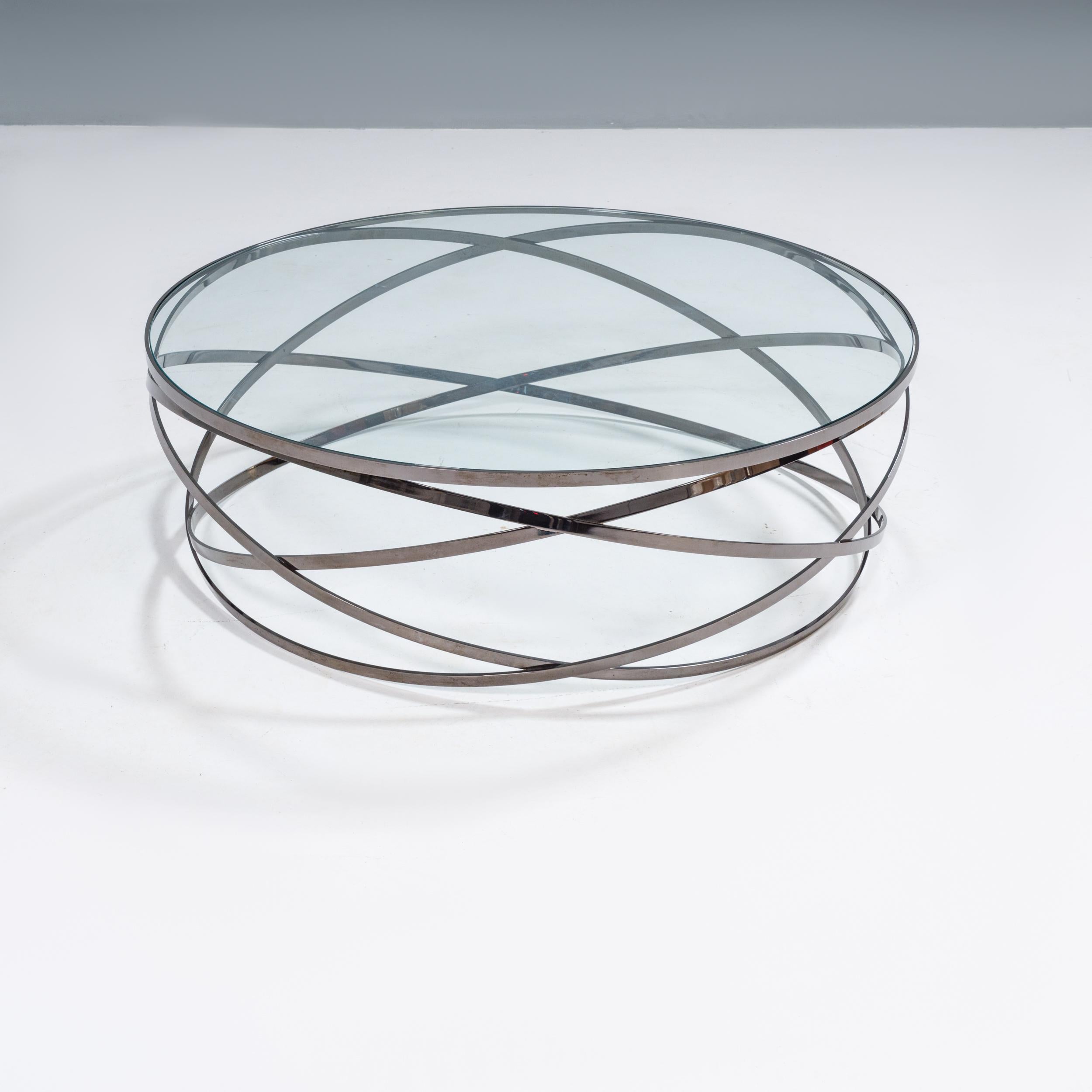 Designed by Cédric Ragot for Roche Bobois, the Evol cocktail table was inspired by a series of photographs of a hoop falling to the ground.

The movement is captured through the use of three intersecting steel circles in a black nickel finish,