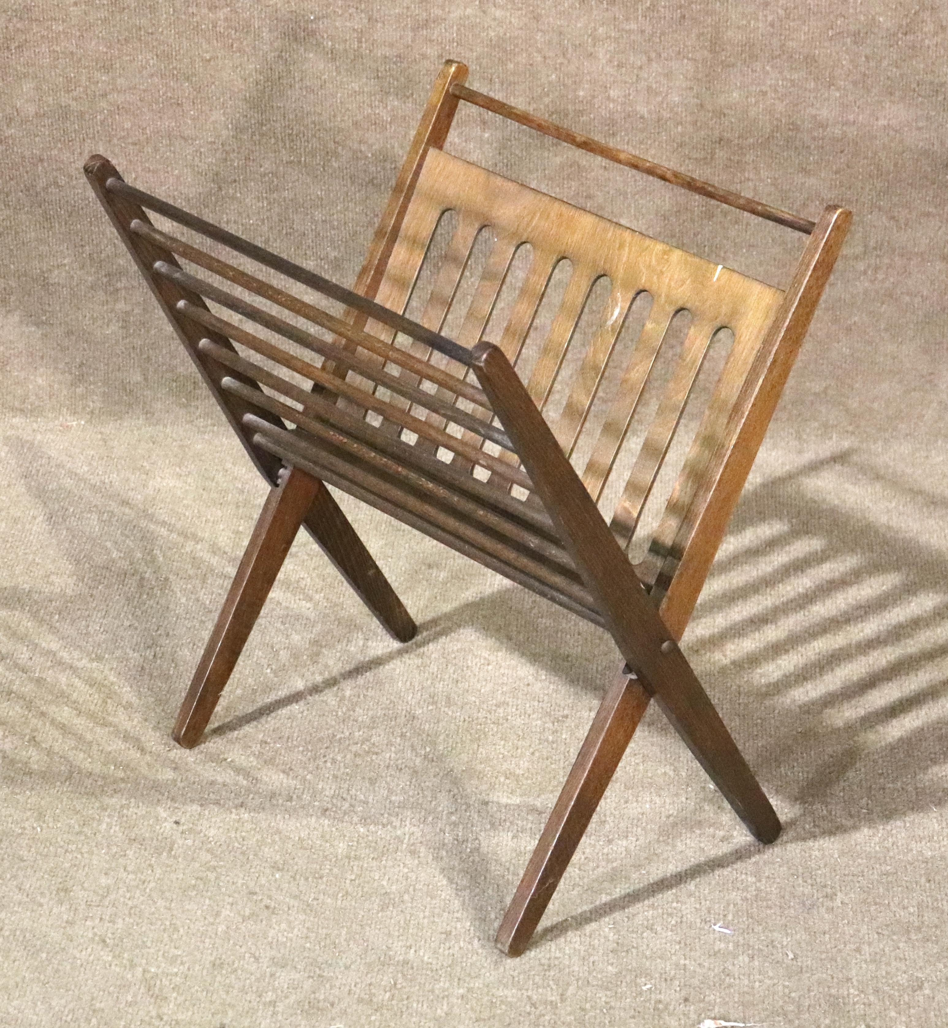 This mid-century modern newspaper rack is made of wood veneer and wooden dowels, and folds up. Designed to store your reading material by placing inside the 'V' shaped cradle, or hanging from each dowel.
Please confirm location NY or NJ