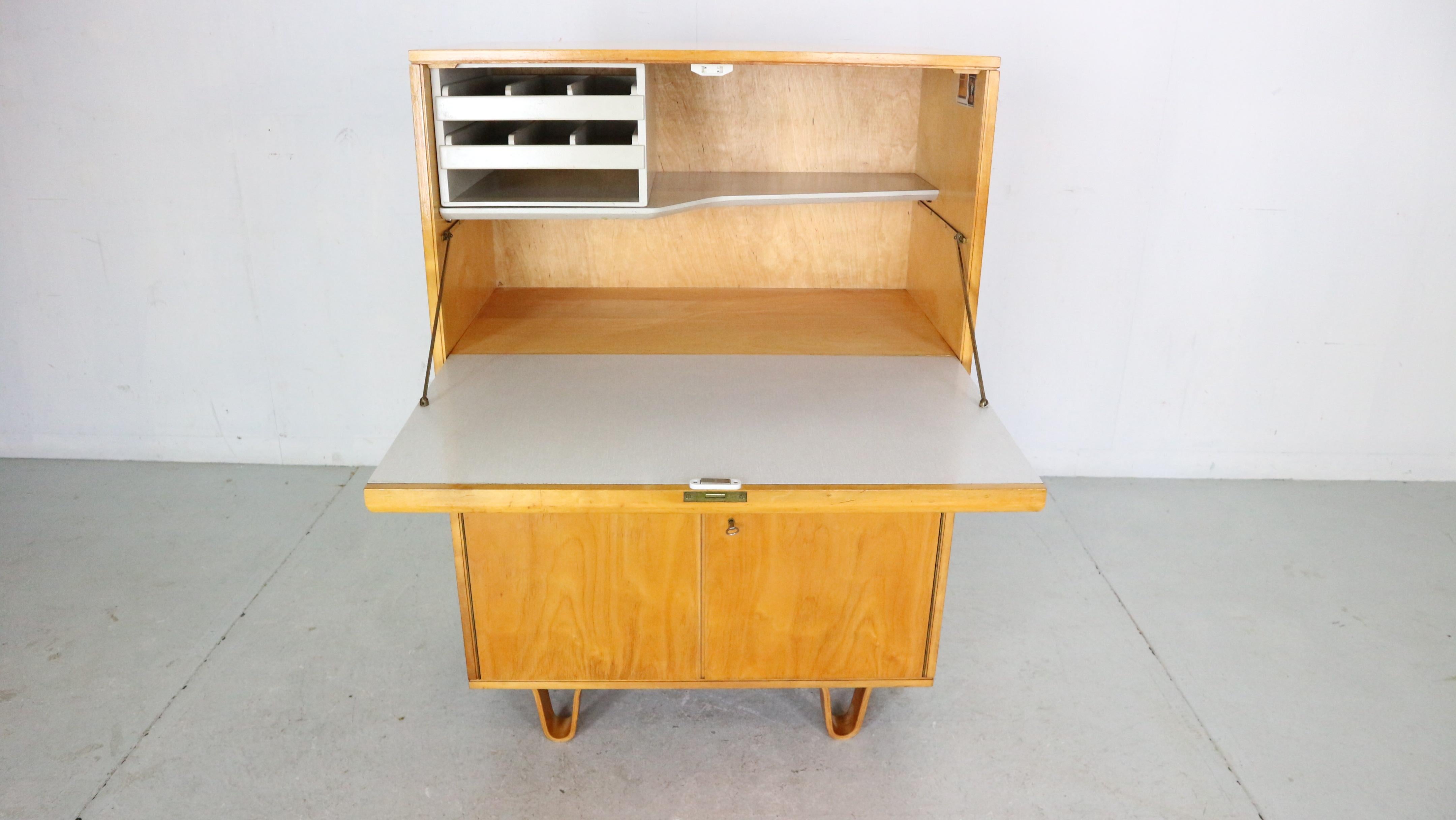 Mid- Century modern period secretary/ cabinet designed by famous Dutch furniture designer Cees Braakman and manufactured by Pastoe in early 1950's period.

Model- CB07
Cabinet has many shelves and drawers for storage. The drop down leave becomes a