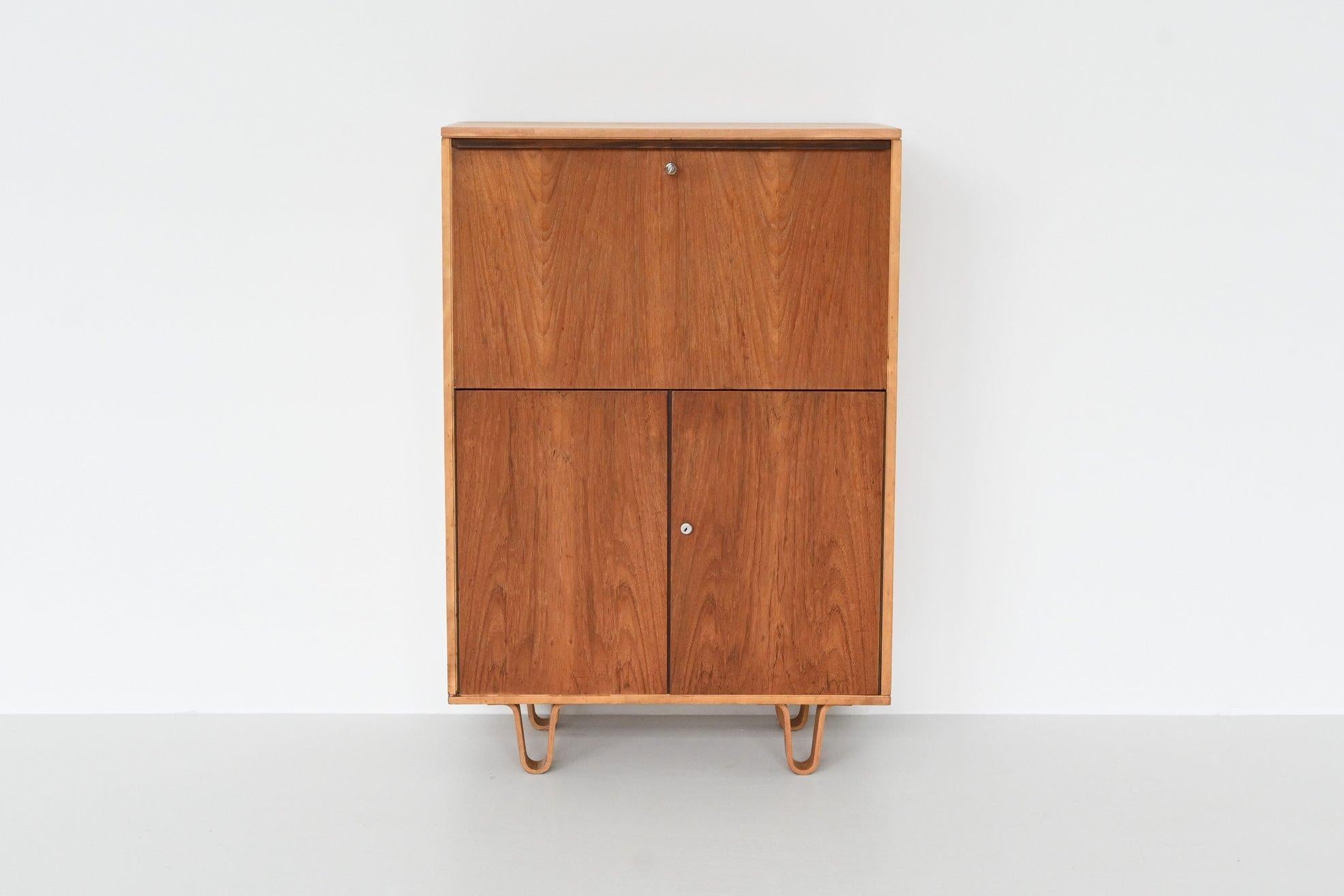 Beautiful cabinet or secretary model CB07 designed by Cees Braakman for Pastoe, The Netherlands 1950.  It is a model from the famous “Combex Series”. This cabinet has a folding door on top with two drawers and shelve inside. Below it has two doors