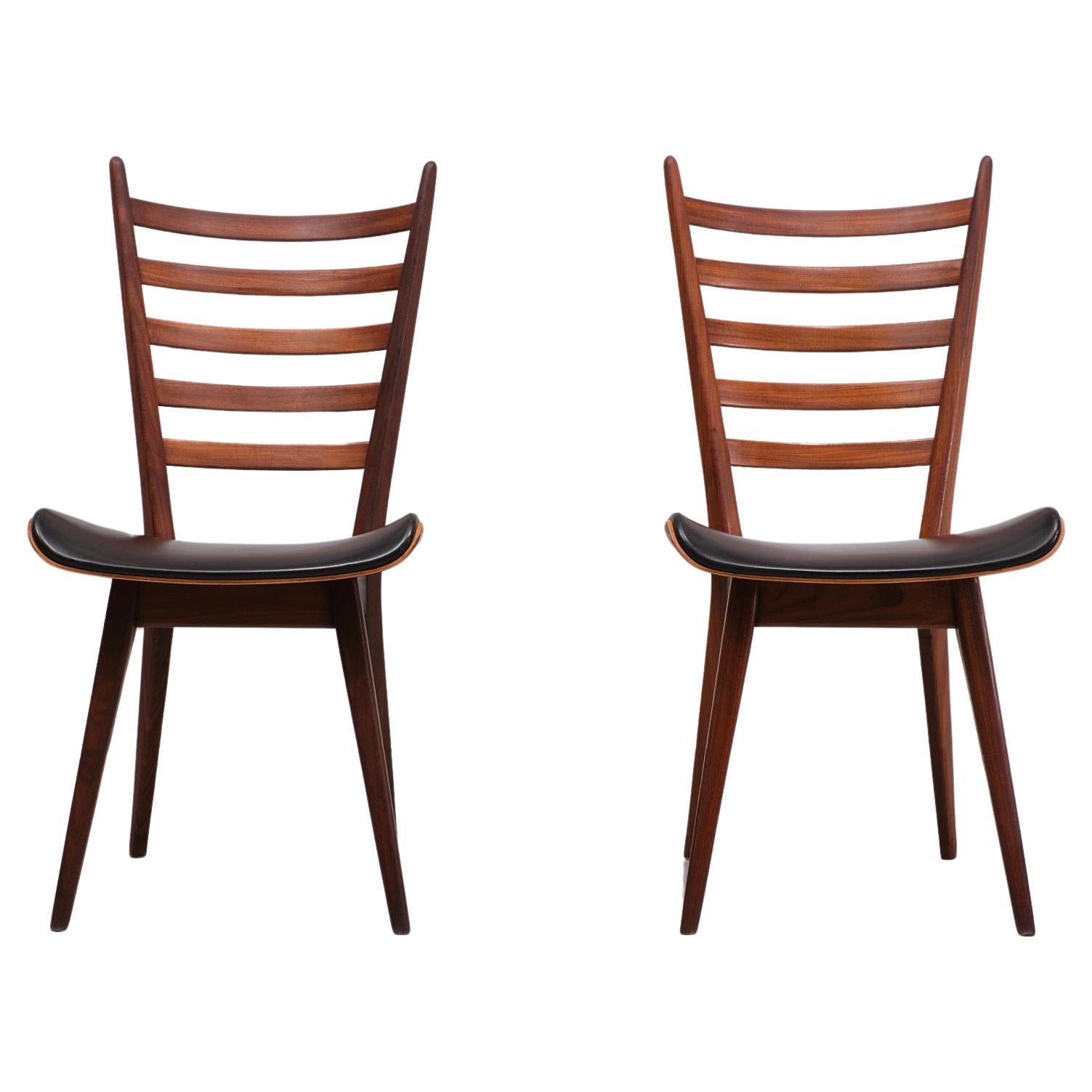 Very nice pair of rare chairs . Nicely curved ladder back ,Solid Teak frame  ,                                                ,comes with beathiful  curved Plywood seat . Upholstered with Black faux Leather .
Very good seating comfort . Design by