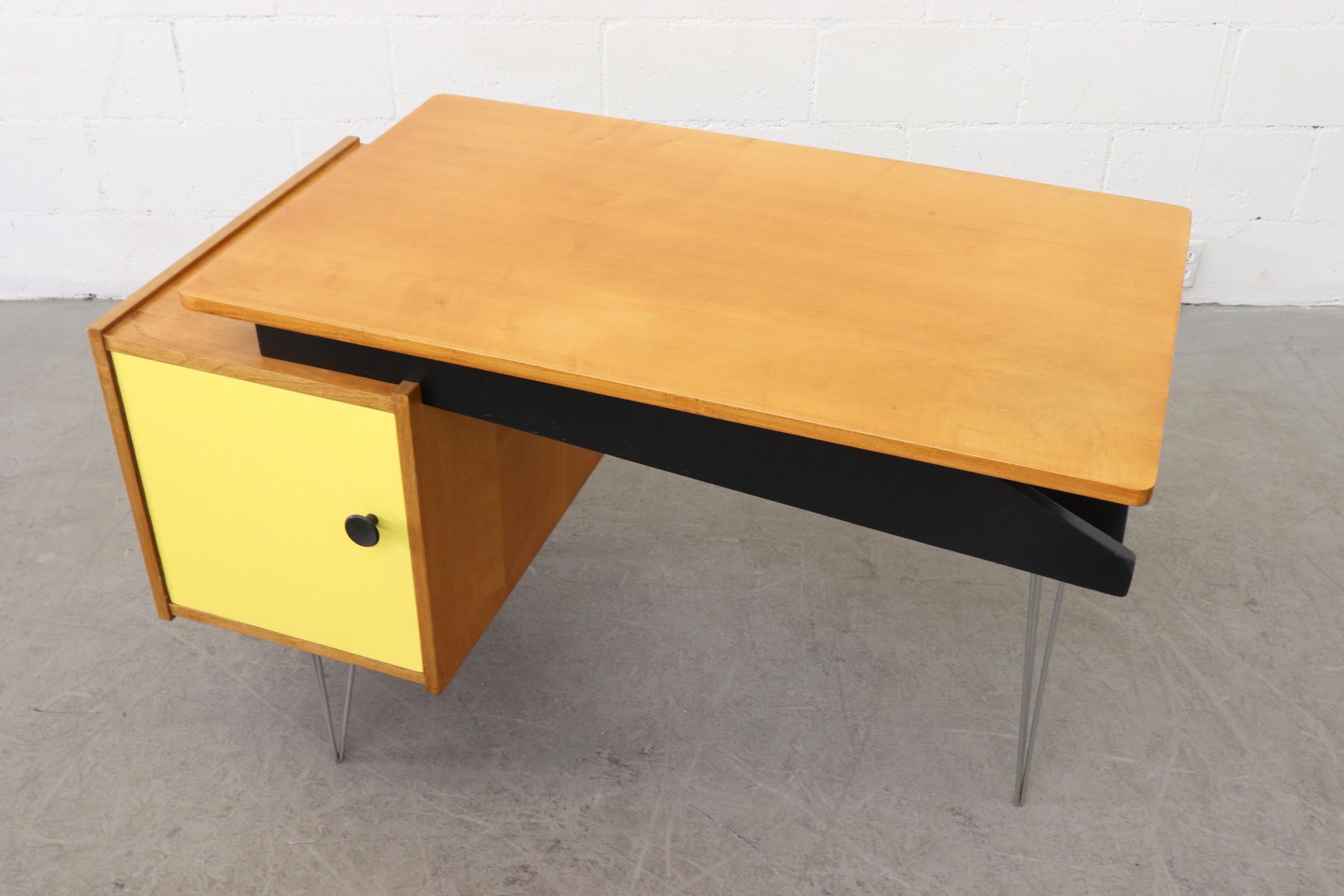 Cees Braakman desk for Pastoe with yellow cubby door and hairpin legs. Unique Asymmetric Design. Lightly refinished. Pull out shelf. In original condition with visible signs of wear consistent with age and use.

Comes with removable small black
