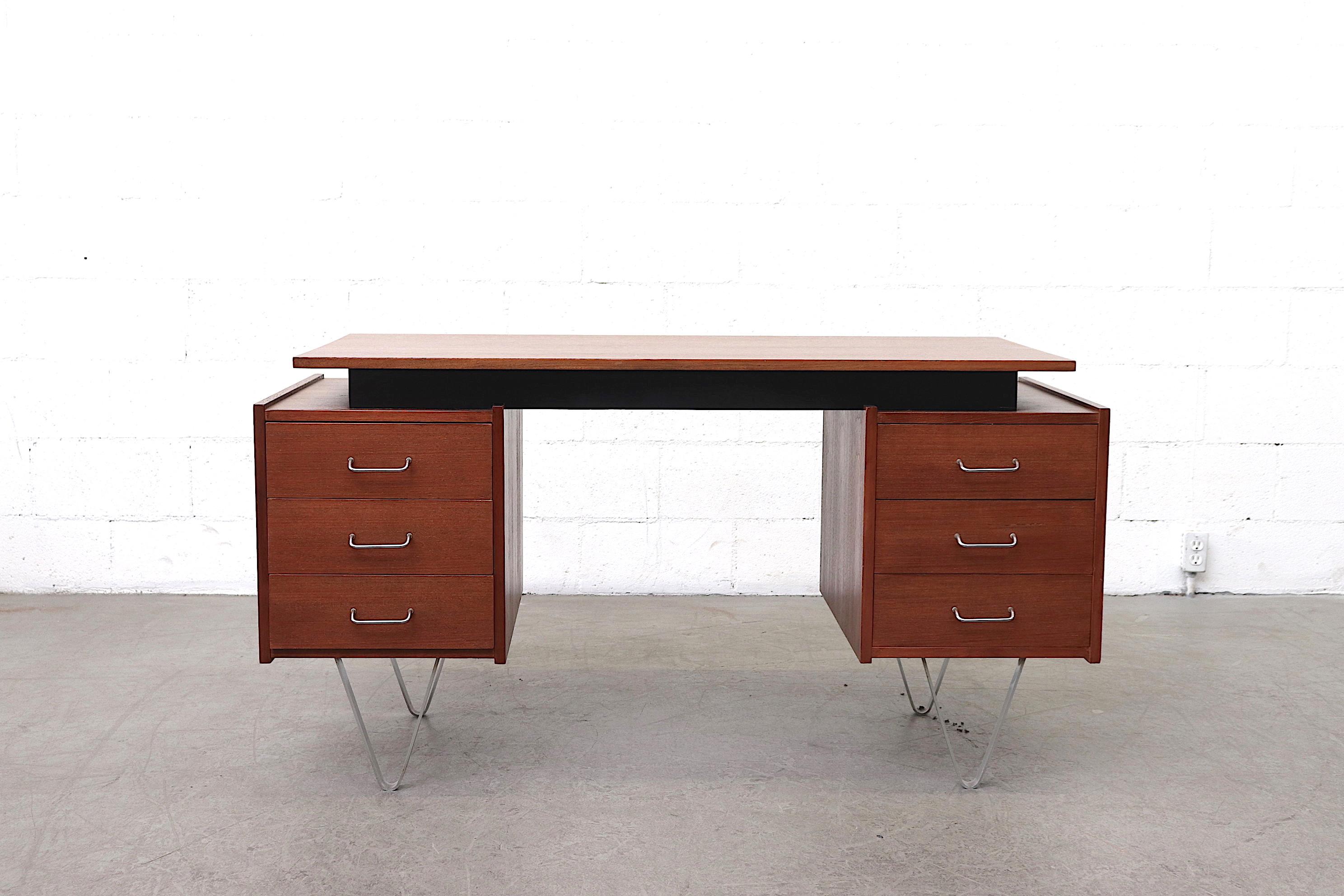 Midcentury executive desk designed by Cees Braakman for Pastoe. Lightly refinished teak. Floating top with black painted wood riser and flat chrome hairpin legs. Good original condition with wear consistent with its age and usage.