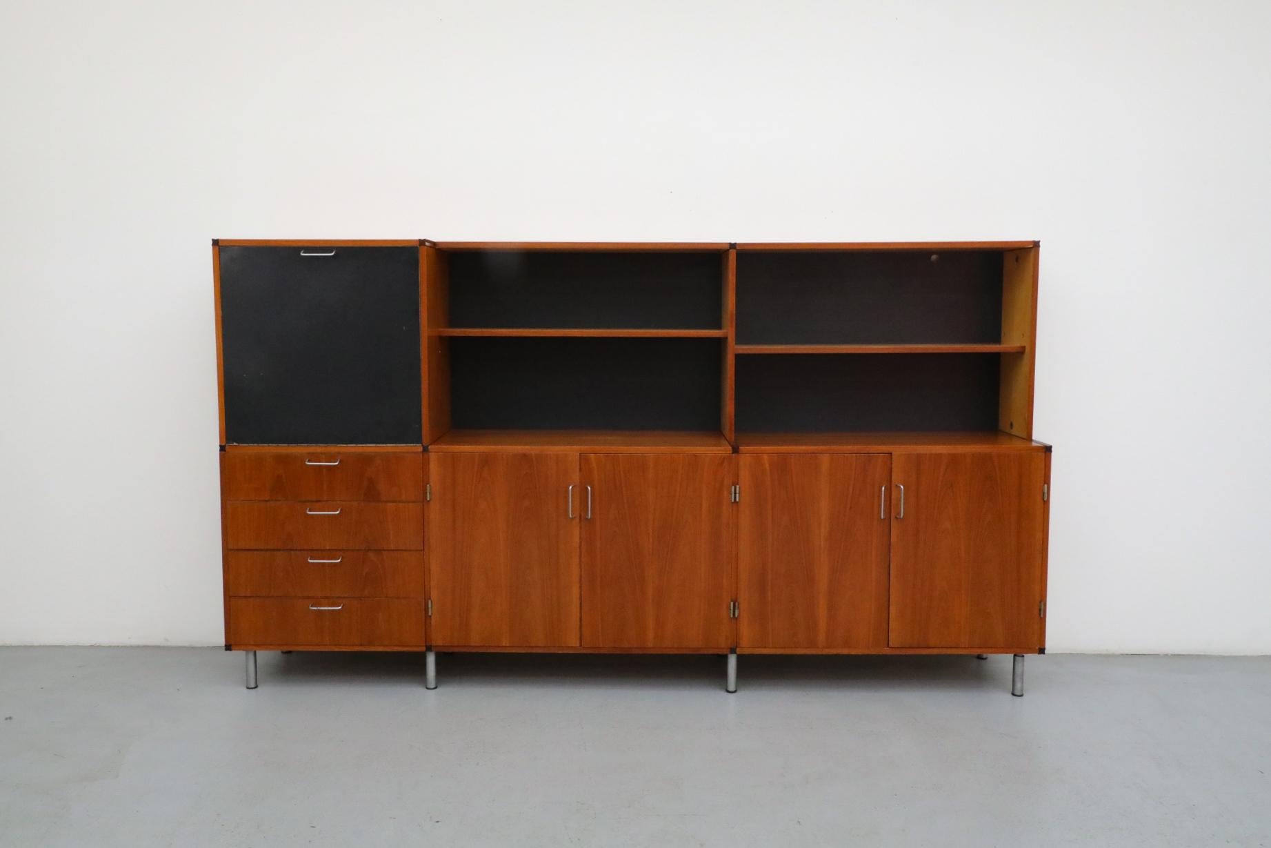 Beautiful Mid-Century made to measure ‘CT69’ storage cabinet by Cees Braakman for Pastoe. Classically styled three section teak storage cabinet with drop-down bar or desk and thin chrome handles. The bar surface is a printed laminate and it's