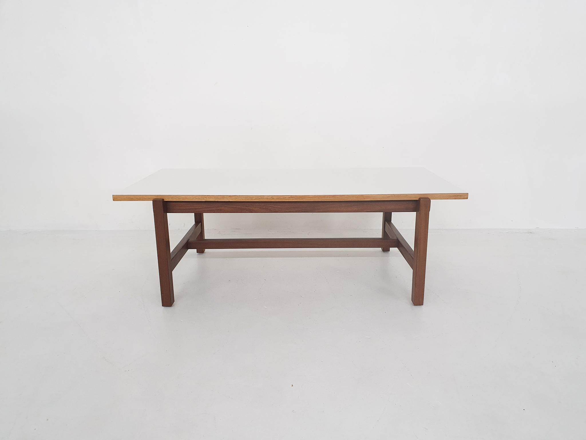 Teak coffee table with a reversible top. One side in teak veneer ad the other side in white formica.
The side of the top, has some veneer damage. The teak top has been refinshed.

Cees Braakman was a Dutch furniture designer who worked for UMS