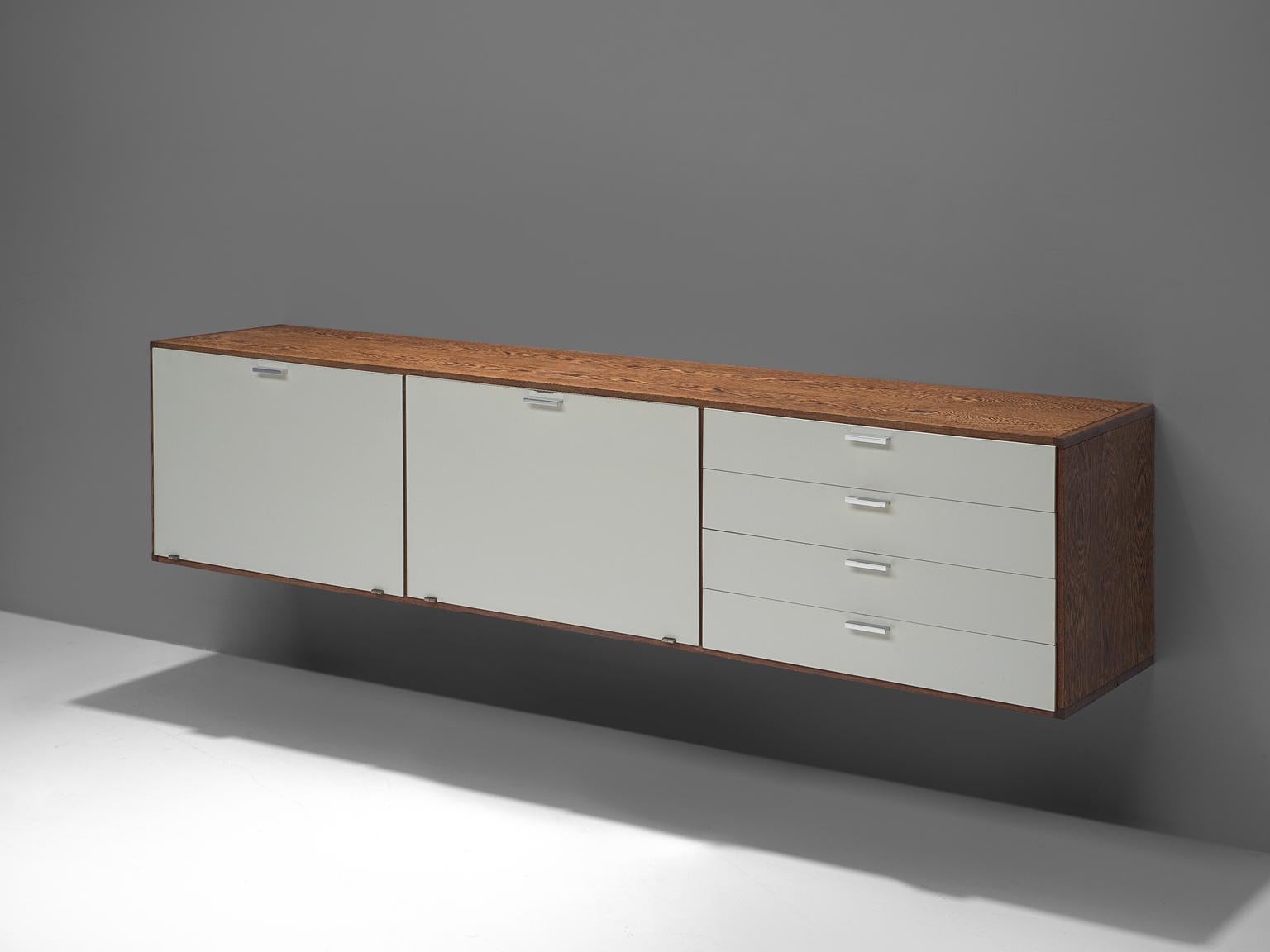 Cees Braakman for UMS Pastoe, wall-mounted sideboard, wengé, steel and lacquered wood, The Netherlands, circa 1960.

This Dutch modernist sideboard designed by Cees Braakman has a wengé storage. It's covered with white lacquered wooden doors which
