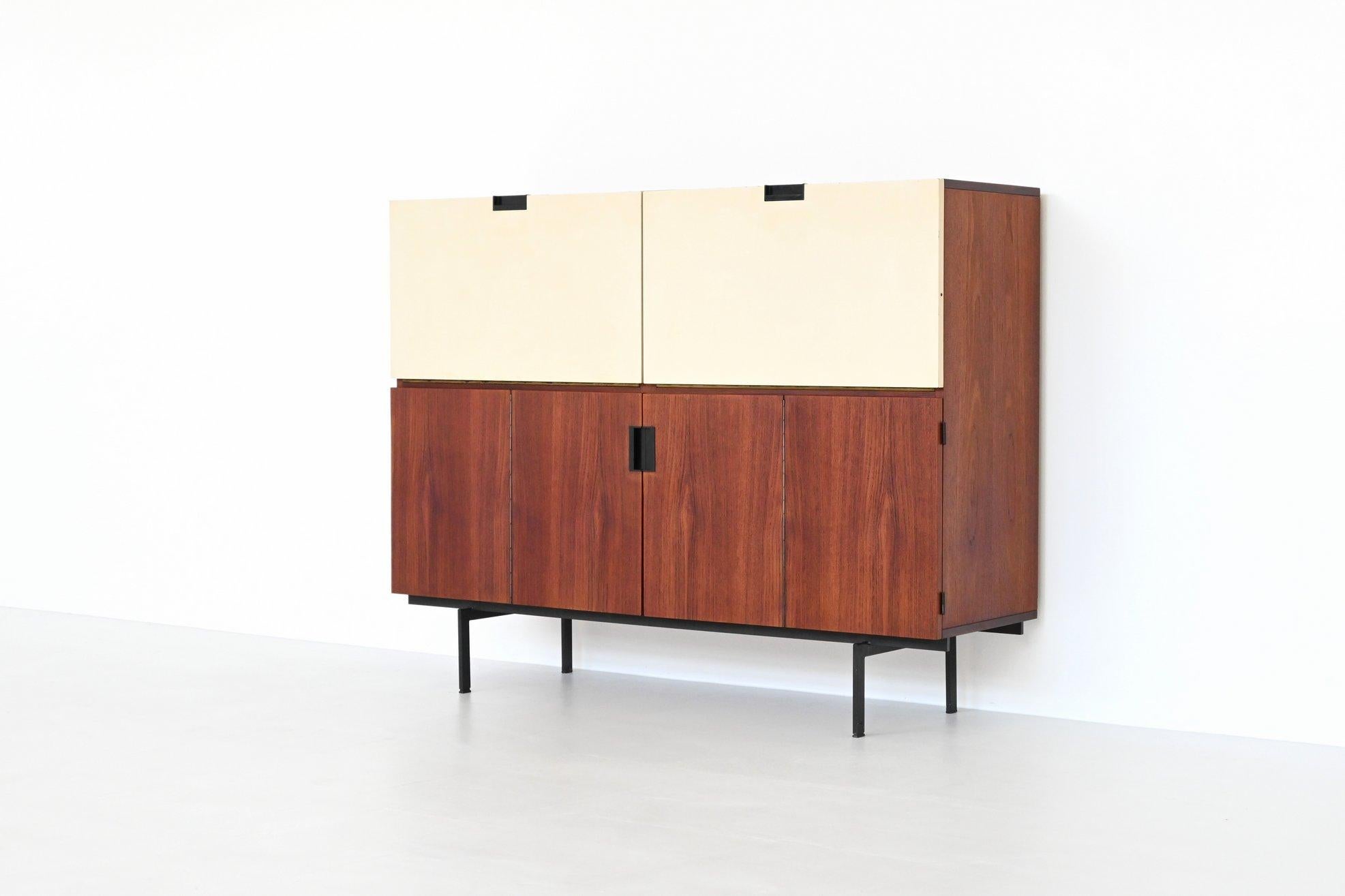 Beautiful symmetric cabinet model CU07 of the Japanese Series designed by Cees Braakman for Pastoe, The Netherlands 1958. This minimalistic high cabinet is made of nicely grained teak wood in combination with two white lacquered dropdown doors and
