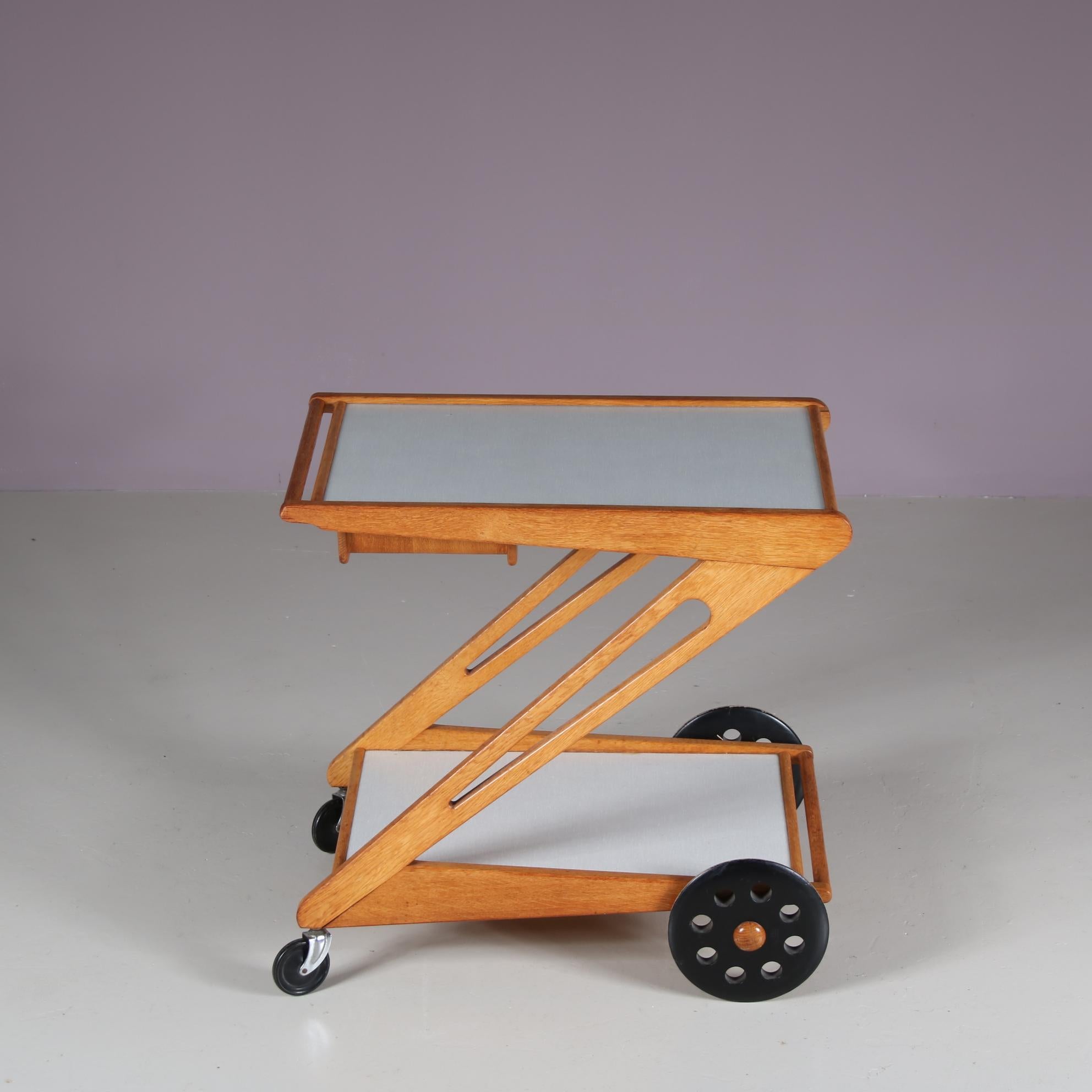 The “Mobilo PE03” trolley was designed by Cees Braakman and manufactured by Pastoe in the Netherlands around 1950.

It features a birch frame with white laminated shelves and a handle on top for easy maneuverability. The trolley has a modern and