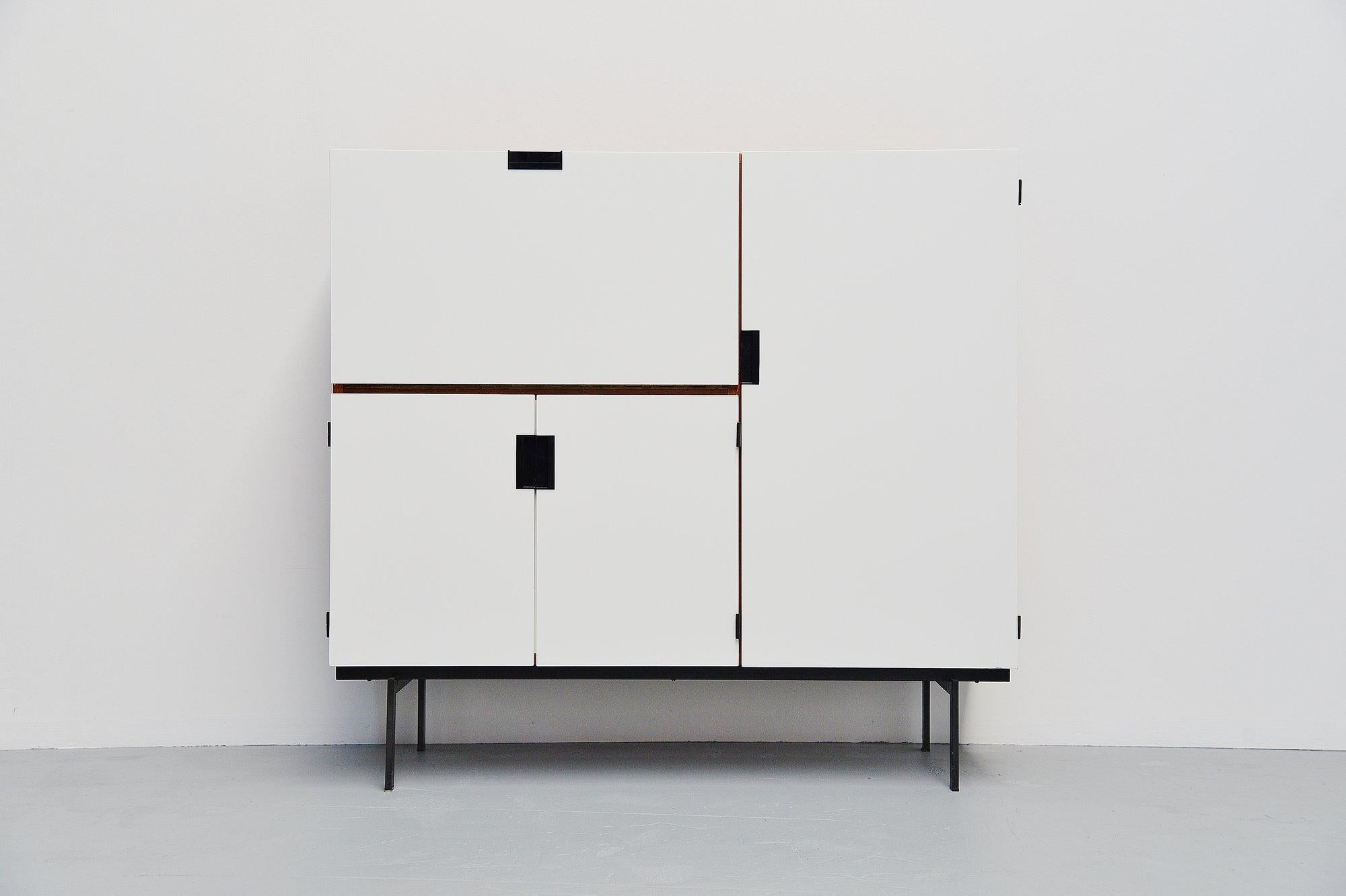 Very nice modernist cabinet designed by Cees Braakman and manufactured by Pastoe UMS, Holland 1958. This minimalist cabinet from the so called Japanese series is made of teak wooden veneer and has a white painted front. The grips are made of black