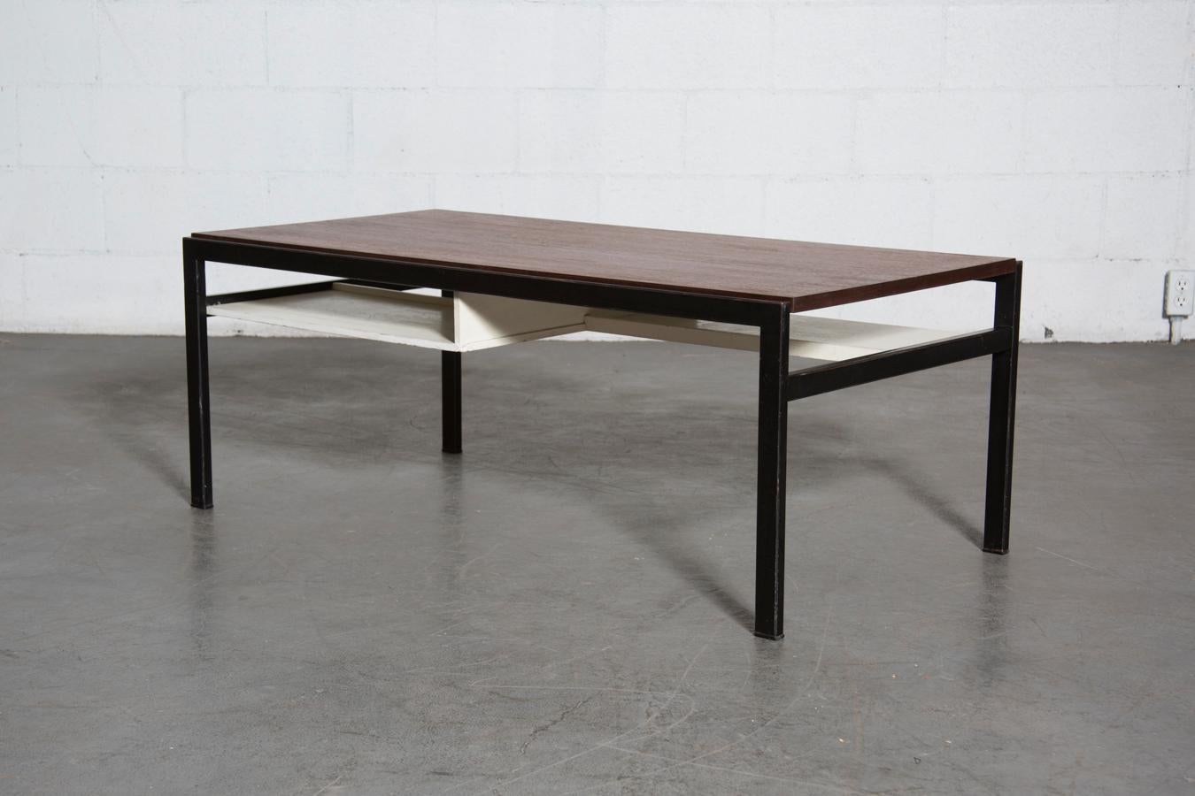 Cees Braakman modernist coffee table with black enameled metal frame and reversible top in dark teak and formica. White wooden lacquered cubby trays or storage. Original condition, Wear to tray below table top and some wear on frame with some