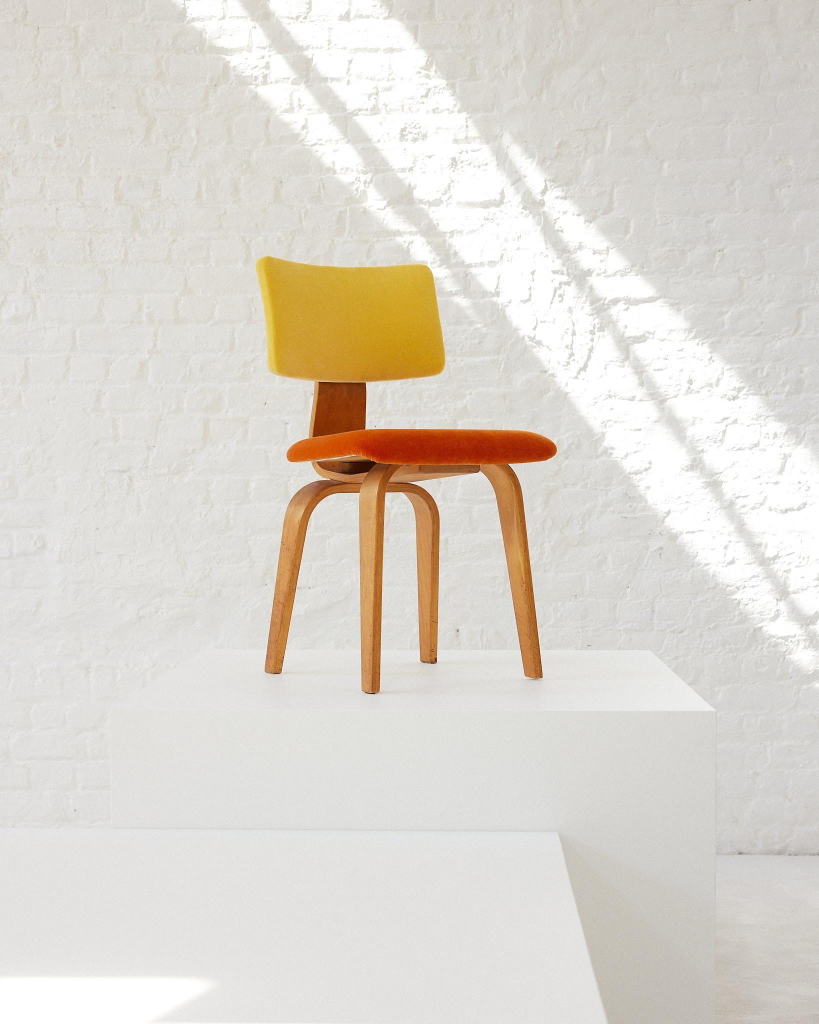 The SB 02 chair was designed in 1952 by Cees Braakman, a Dutch designer. The chair is a result of learning new methods in bent plywood once he travelled to the US. This piece is made from birch plywood, covered with a velvet material cushion.