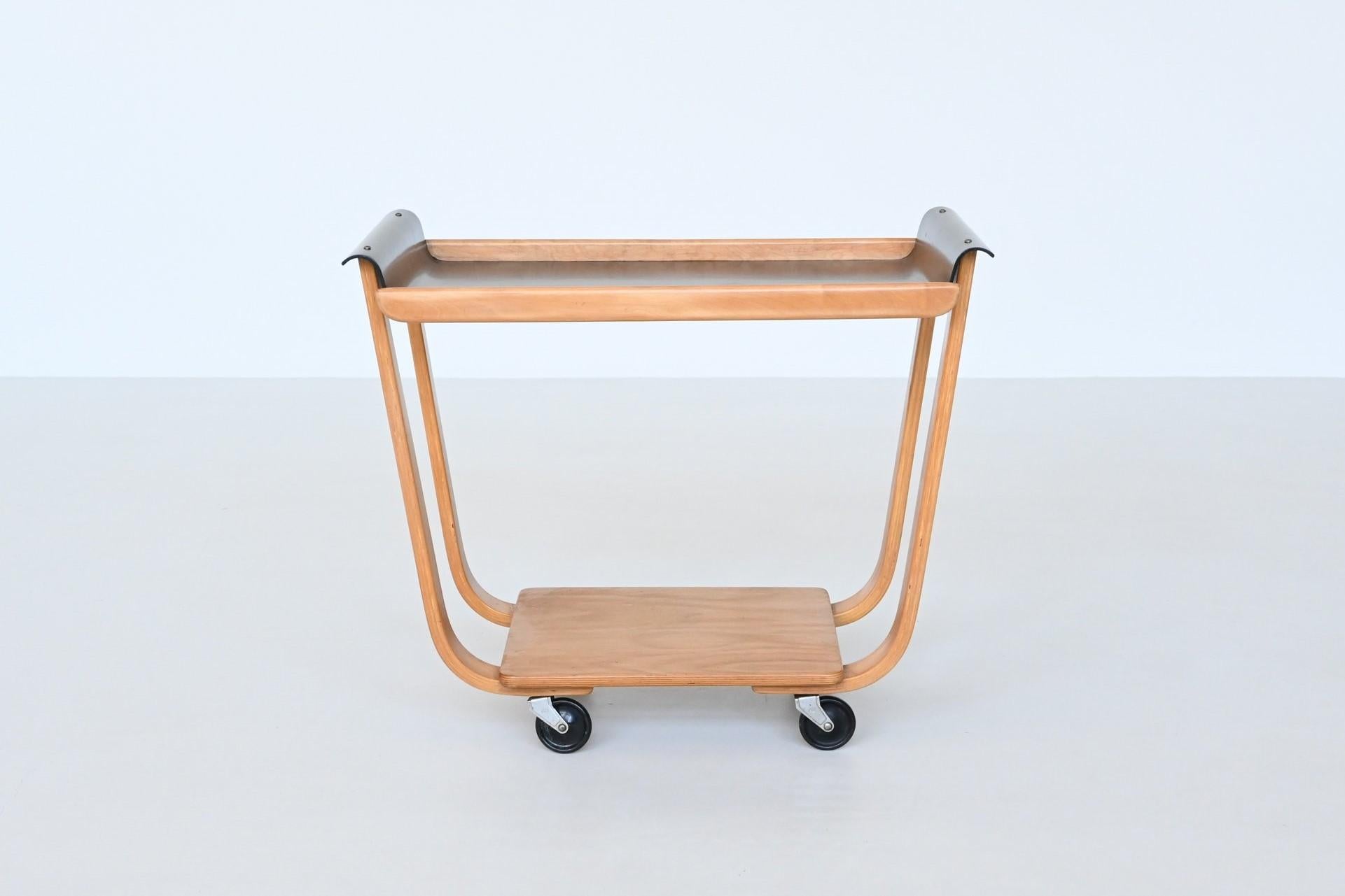 Very nice iconic serving trolley model Rolo PB31 designed by Cees Braakman for UMS Pastoe, The Netherlands 1950. This beautiful serving trolley is made of birch veneered plywood and has a black lacquered top. The top features organically curved