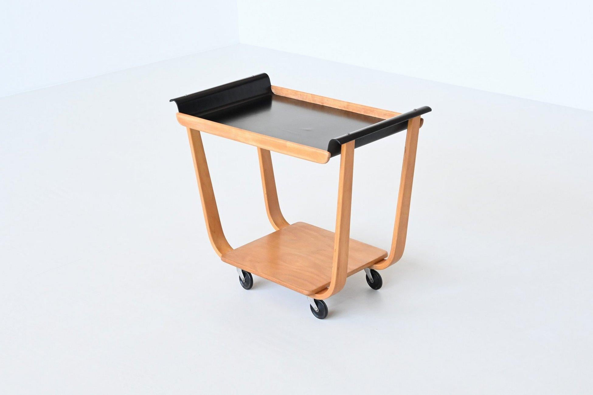 Very nice iconic serving trolley model Rolo PB31 designed by Cees Braakman for UMS Pastoe, The Netherlands 1950. This beautiful serving trolley is made of birch veneered plywood and has a black lacquered top. The top features organically curved