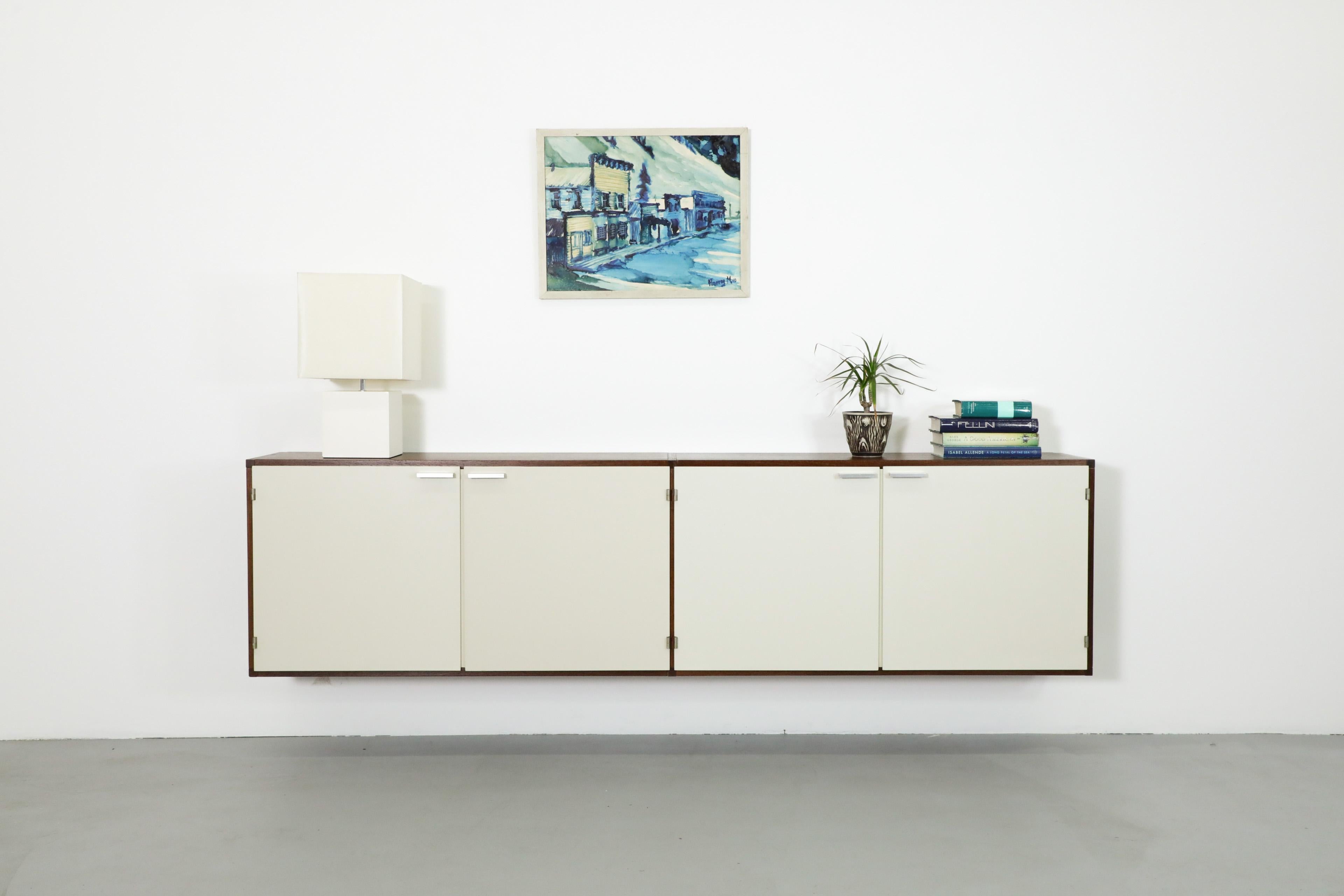 Wall mounted, Dutch Mid-Century, Cees Braakman designed skinny credenza with wenge frame, bone white lacquered doors, adjustable shelves and signature cast aluminum handles. Made by widely acclaimed Dutch furniture manufacturer Pastoe Lightly