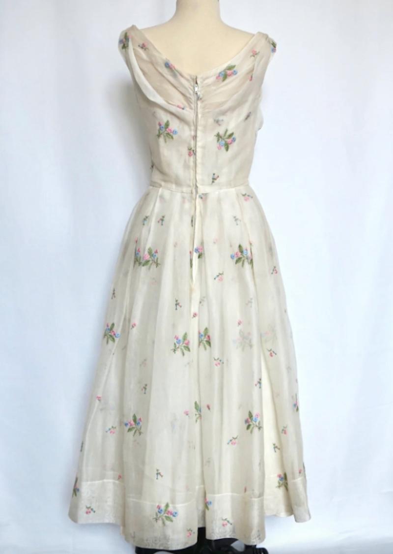 Ceil Chapman 1950's Weißes Leinenkleid mit gestickten Blumen. Ein wunderschönes, detailreiches Kleidungsstück mit prächtigen Drapierungen und einem Korsett - aus einer Ära tadelloser Handwerkskunst. 

Büste 30 in
Taille 23 Zoll
Länge 40