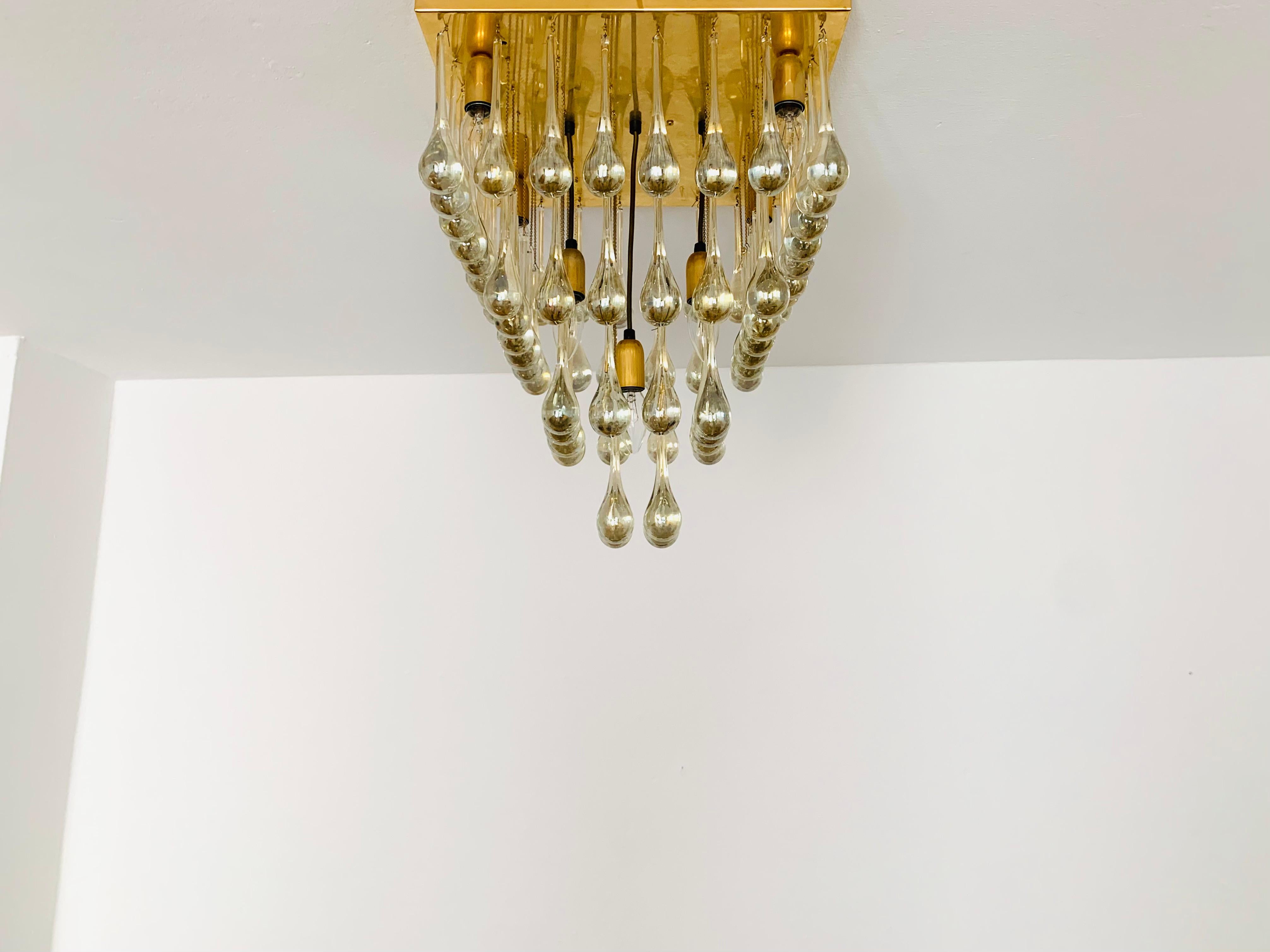 Imposing glass ceiling lamp from the 1960s.
Extraordinarily successful design and very high-quality workmanship.
The 64 glass drops spread a spectacular play of light in the room.
Very luxurious and an asset to any home.

Condition:

Very good