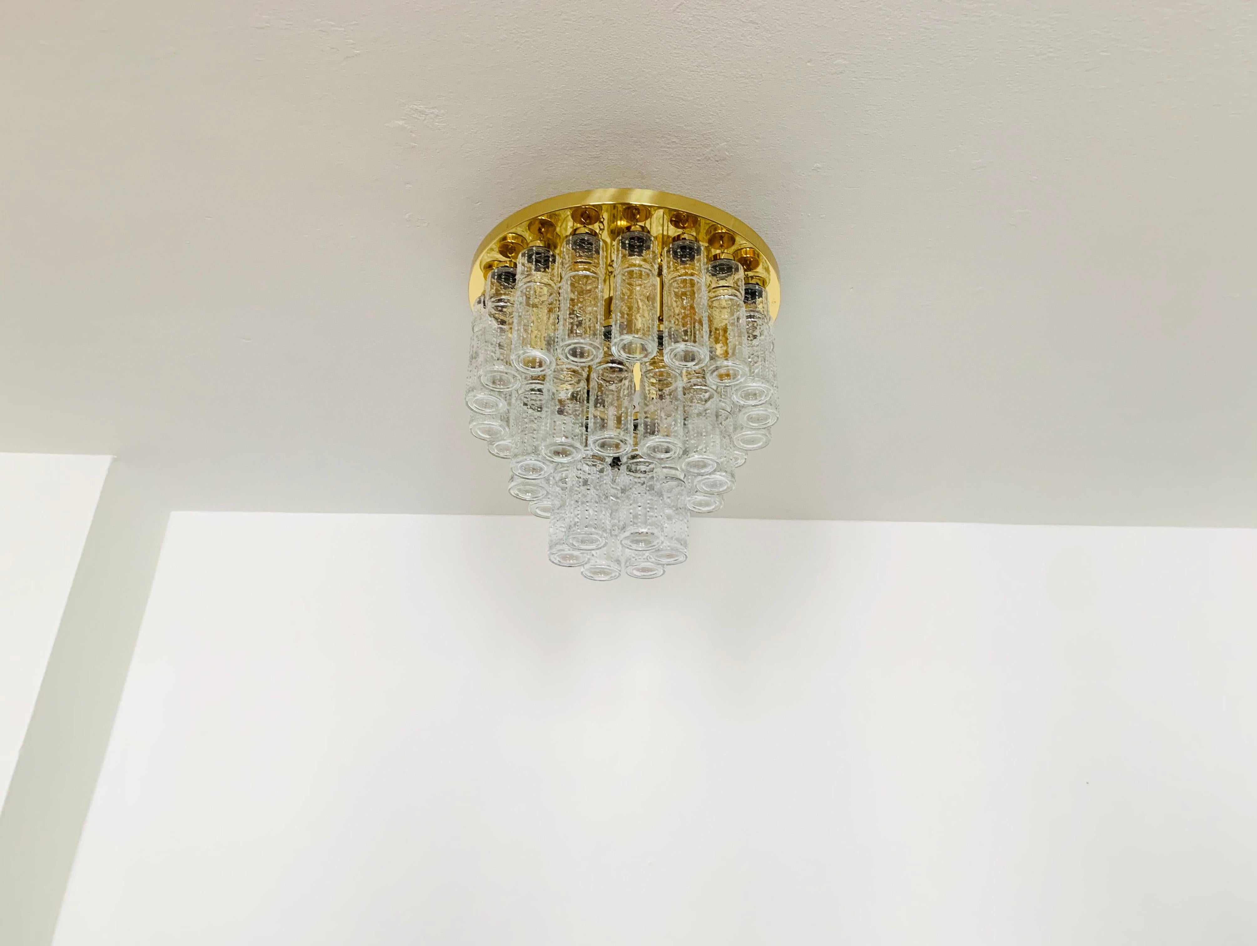 Impressive ice glass ceiling lamp from the Limburg glassworks around 1960.
The lamp spreads a wonderful play of light and is a real eye-catcher.
The 36 glass elements are suspended on 3 levels.
Very elegant design and high-quality