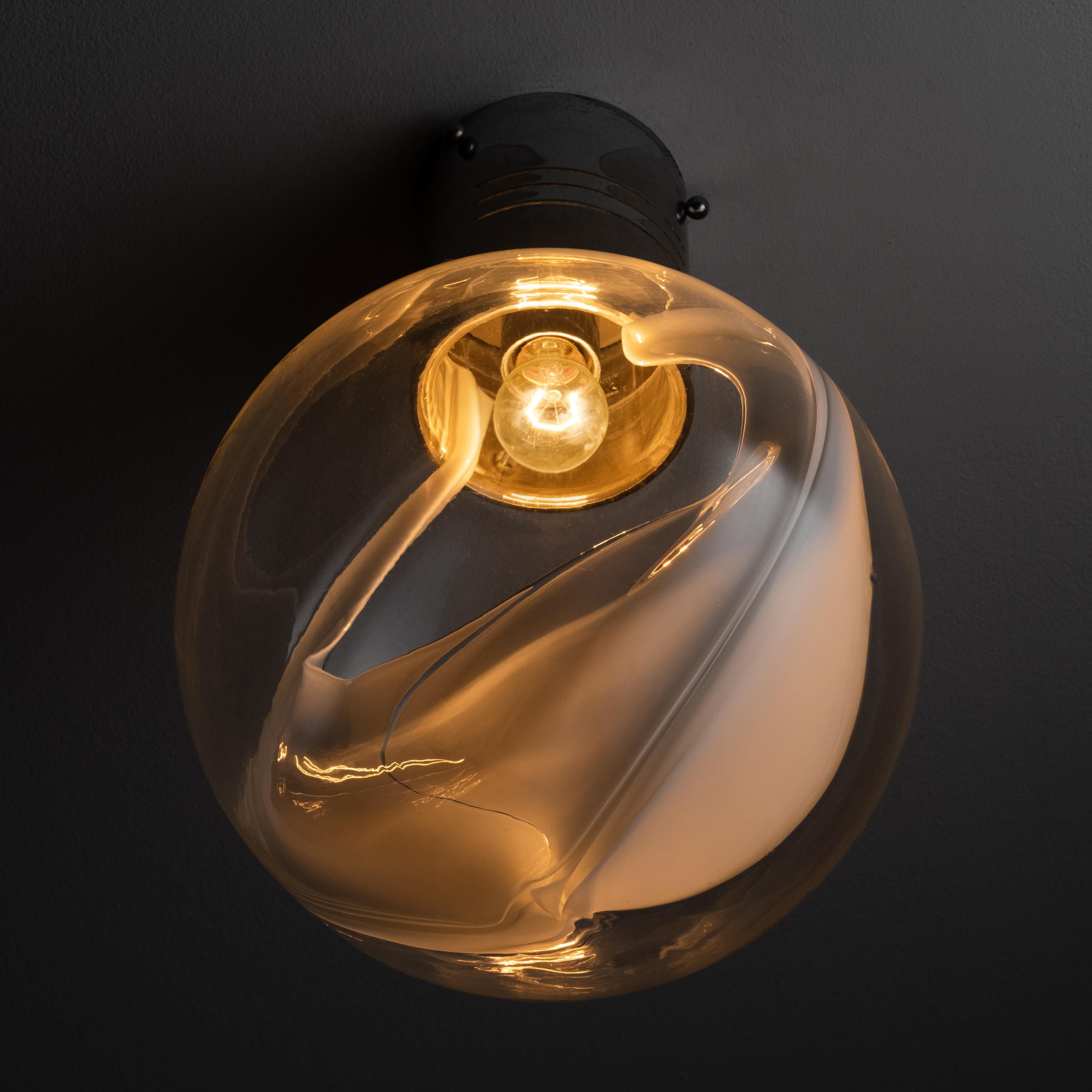 Ceiling flush mounts by Toni Zuccheri for Venini. Spherical lamp shades with hand blown membrane-like glass interior detail, adhered to a cylindrical chrome base for a perfect flush mount effect. We recommend one E27 40w maximum bulb per sconce.