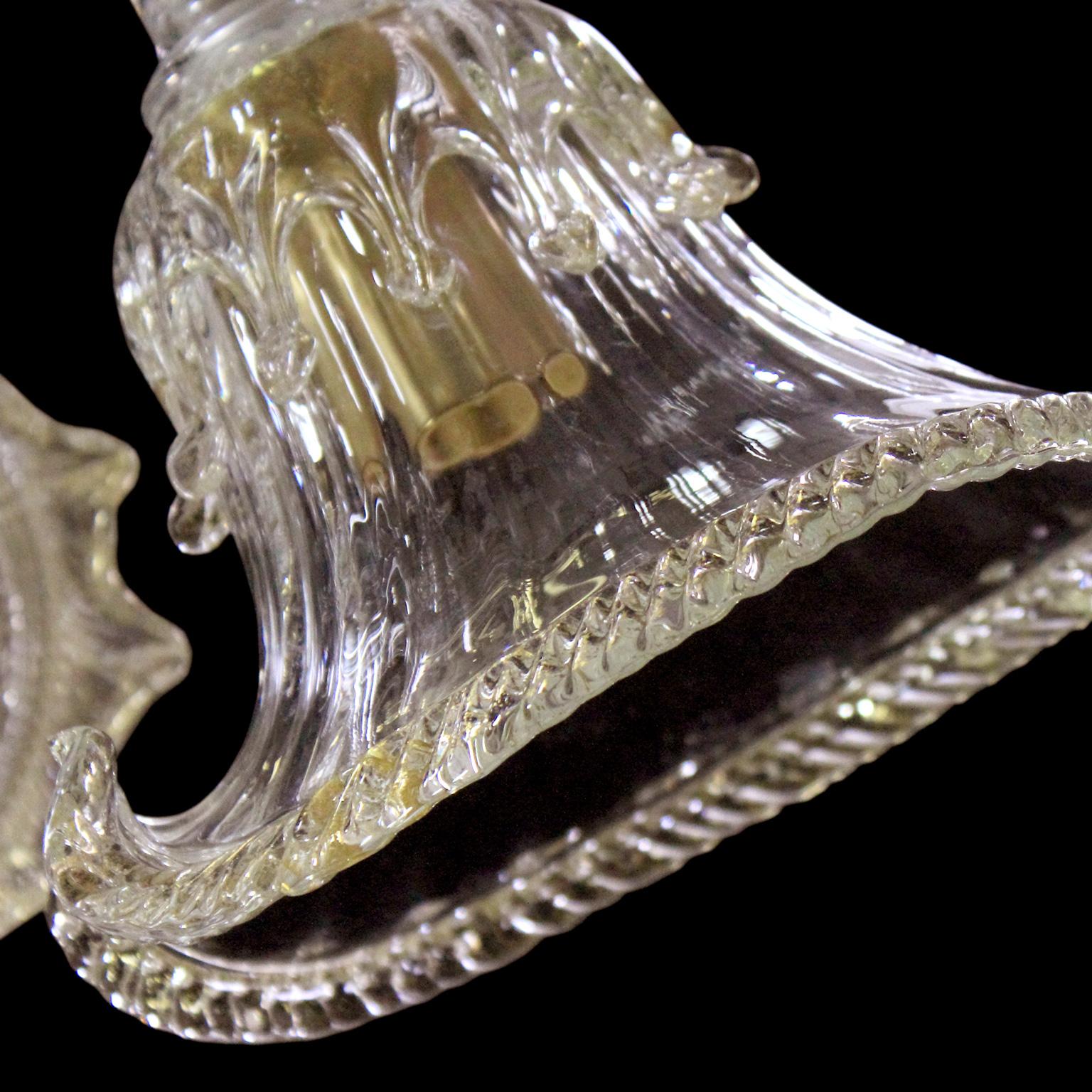 Diese venezianische Deckenleuchte mit Kristall- und Golddetails aus kunstvollem Muranoglas präsentiert ein organisches Design, das das Ergebnis einer Inspiration aus der Natur ist. Die Schalen und einige Details erinnern an den flüssigen Fluss des