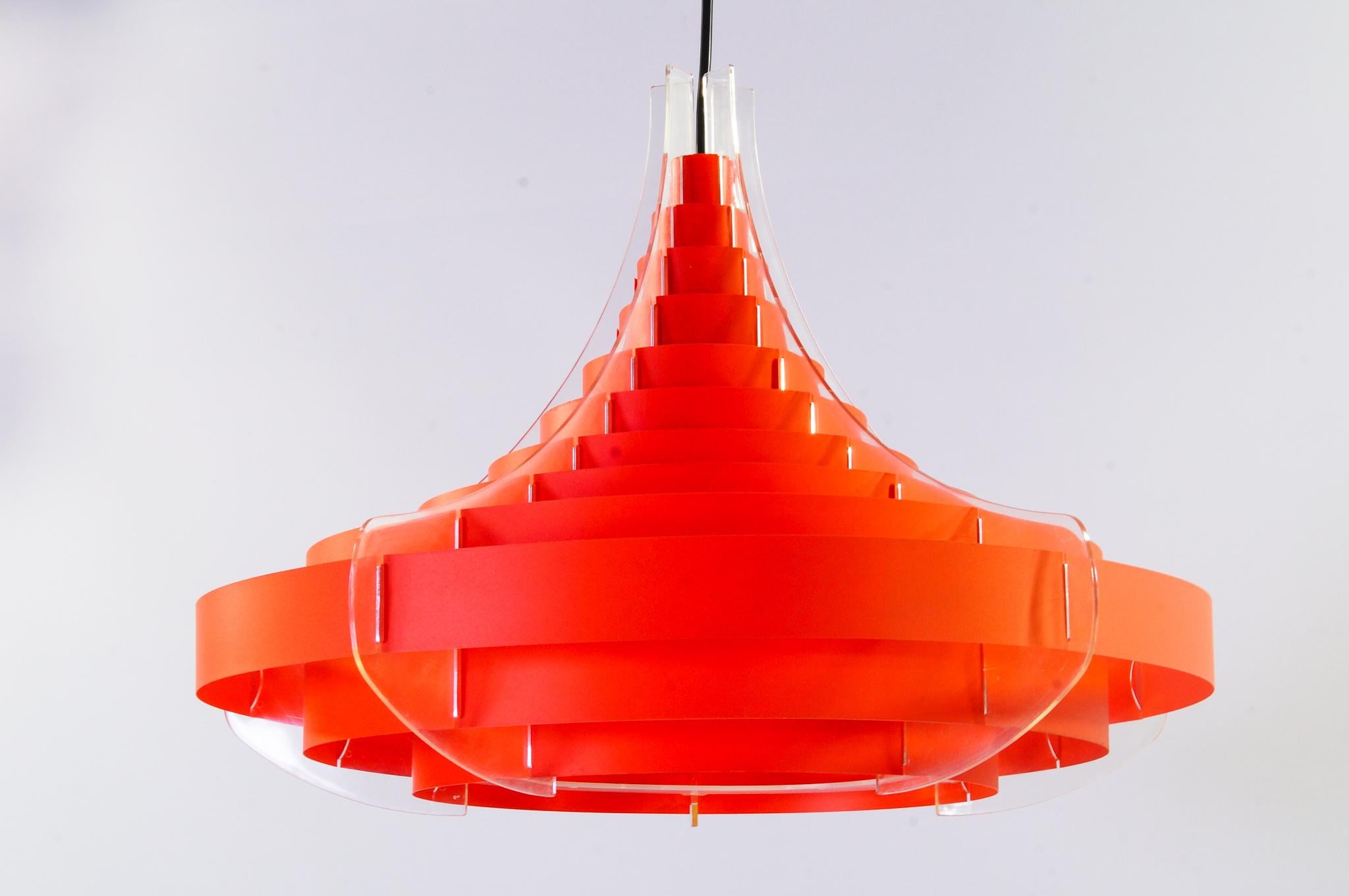 Ceiling lamp by Flemming Brylle & Preben Jacobsen.

Denmark, 1960's

This plexiglass and red acrylic strips make this particulary shaped Danish ceilinglamp a very special addition in eery interior. The light diffuses fantastic. Artist Flemming