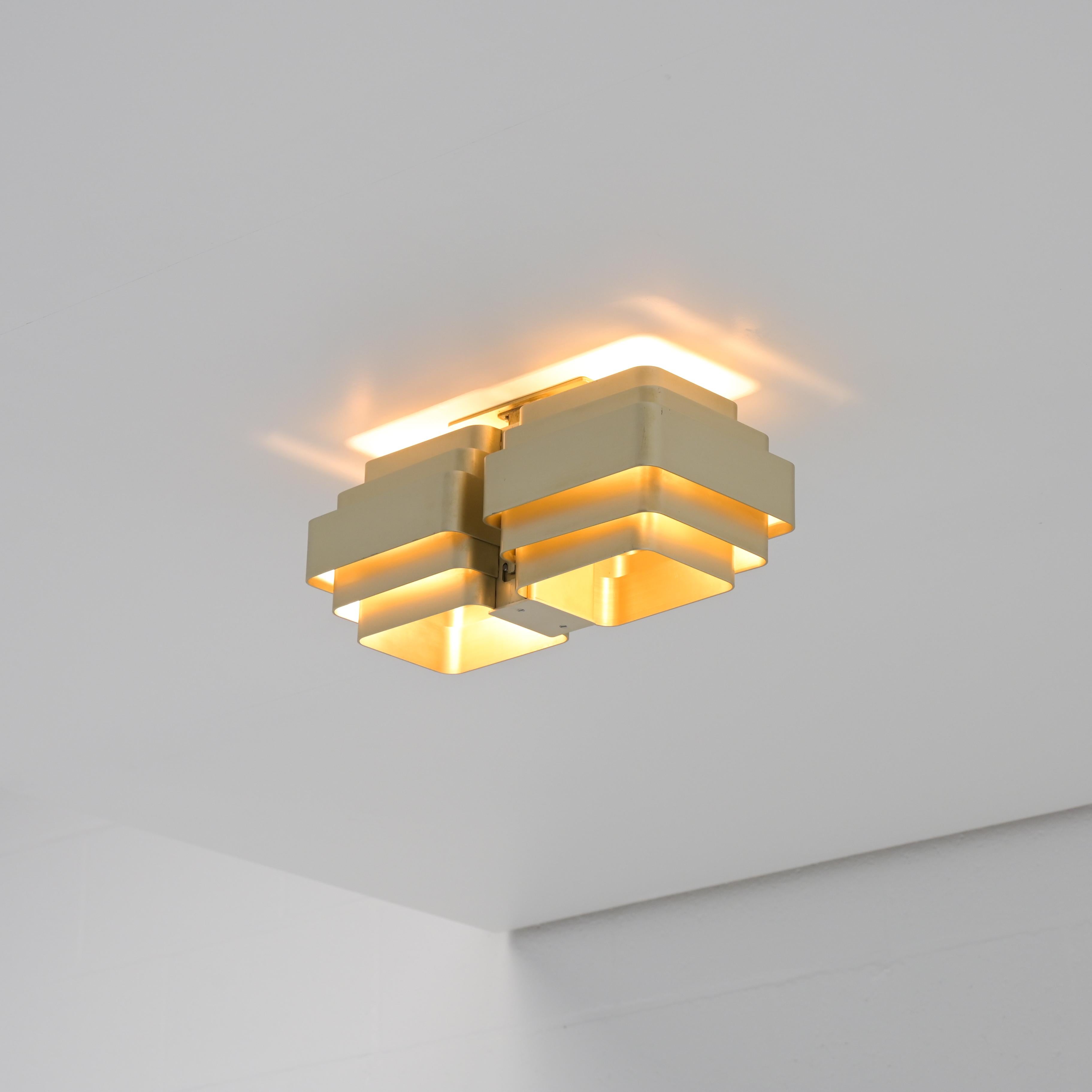 This Jules wabbes ceiling lamp is a special version. The lamp is made of gold anodized aluminum and consists of 2 wall lamps that are joined together in the factory.

Please look carefully at the photos, they are part of the description