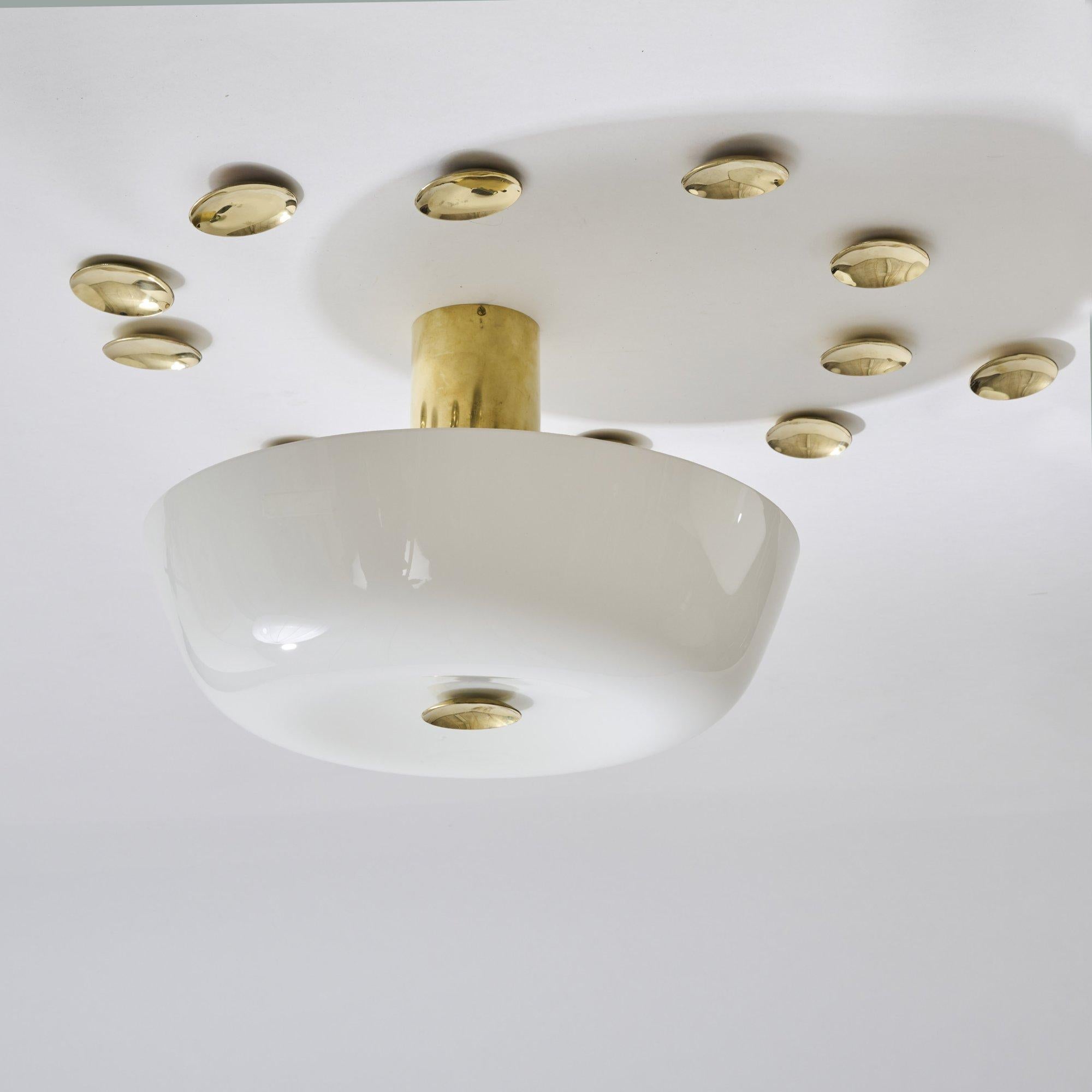 Due bellissime lampade da soffitto di Paavo Tynell degli anni '50. Whiting: steli tubolari in ottone, paralumi in vetro bianco con gocce concave in ottone che creano bellissimi riflessi.

Un inserto in vetro con crepa rinforzata.