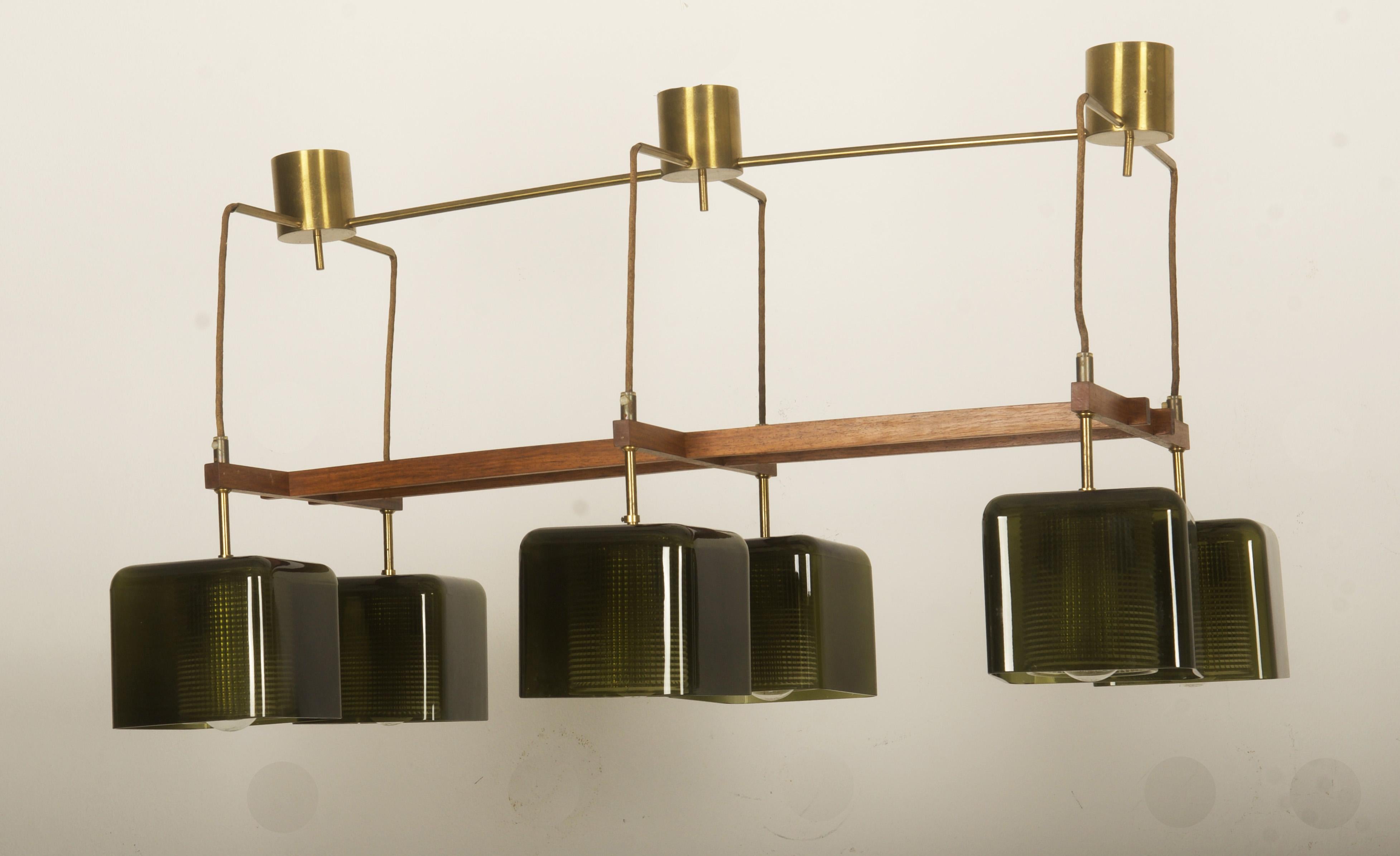 Lampadario progettato da Carl Fagerlund per Orrefors Glassworks. Lampada da soffitto con sospensione in legno duro, sei paralumi in vetro verde oliva e vetro interno trasparente a doppia ondulazione. 
Letteratura/Provenienza: Letteratura: Vetro