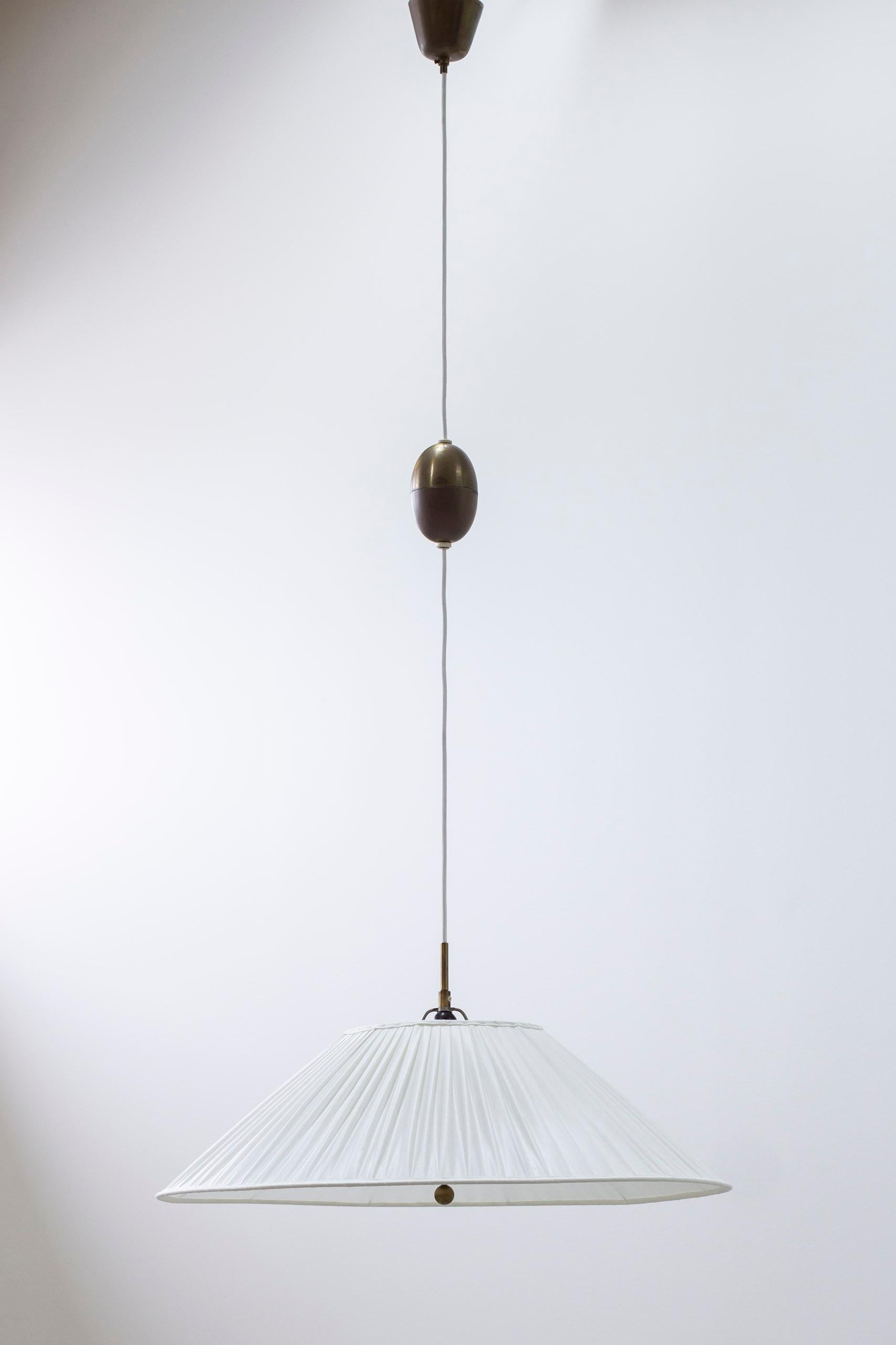 Ceiling lamp designed by Harald Notini. Produced in Sweden by Arvid Böhlmarks lampfabrik during the 1940s. Made from Opal glass with a hand pleated shade in off-white chintz fabric resting on the glass. Ceiling mount, pulley and grip all in brass.