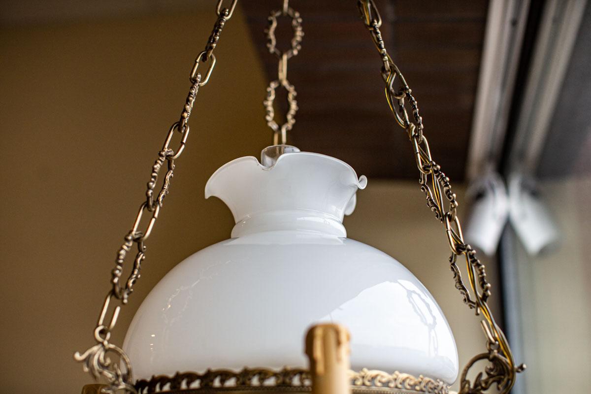 Ceramic Ceiling Lamp from the 1970s with Brass Element Stylized as Kerosene Lamp

We present you this modern electric lamp stylized as an old kerosene lamp.
The metal elements are made of brass, the lampshade of milk glass, where the lower elements