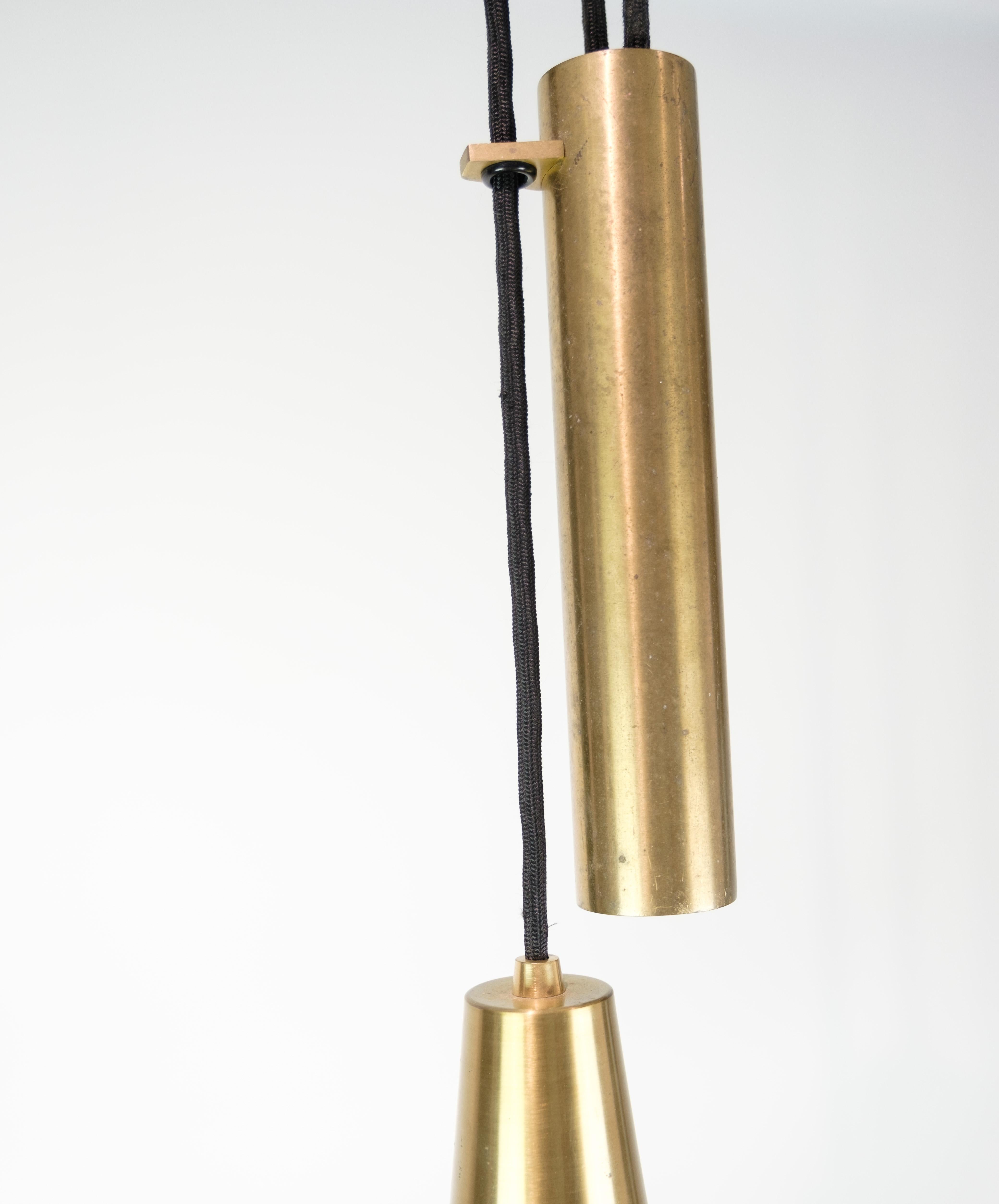 The ceiling lamp with counterweight pendant in brass, manufactured by Lyfa in 1960, is an impressive example of Danish lighting design from the mid-20th century. This lamp combines functionality and aesthetics with an exquisite use of