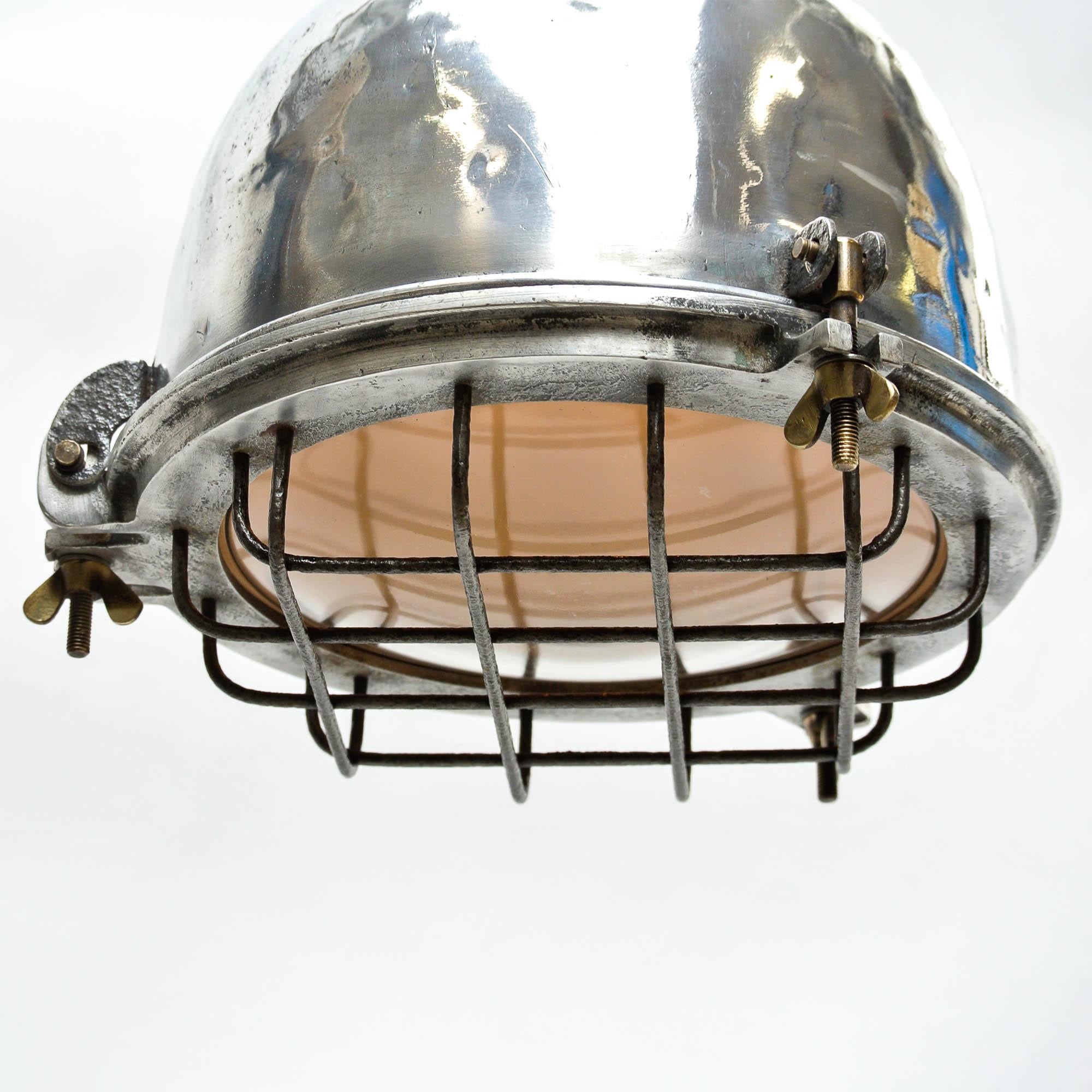 Old ceiling lamp originally used on a oil plateform, fully restored. The light have been stripped and polished, the slightly domed glass is protected by a pretty grid made of steel (brushed and varnished). Opening with butterfly screw made of brass.