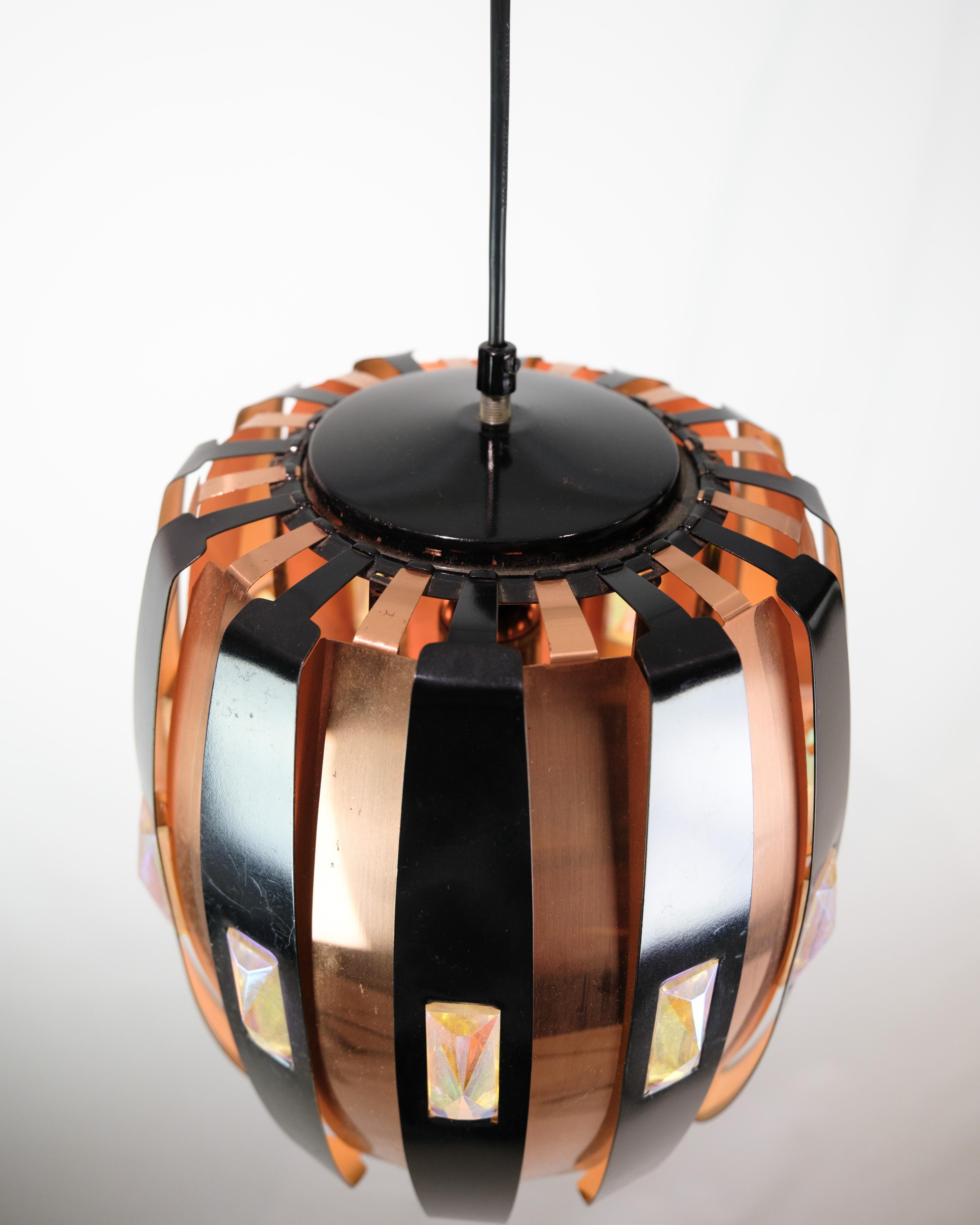 The ceiling lamp in copper, decorated with crystals, created by Werner Schou and produced by Coronell Elektro Denmark in 1970, is a magnificent example of lighting design from this era. Combining the warm shades of copper with the luxurious shine of
