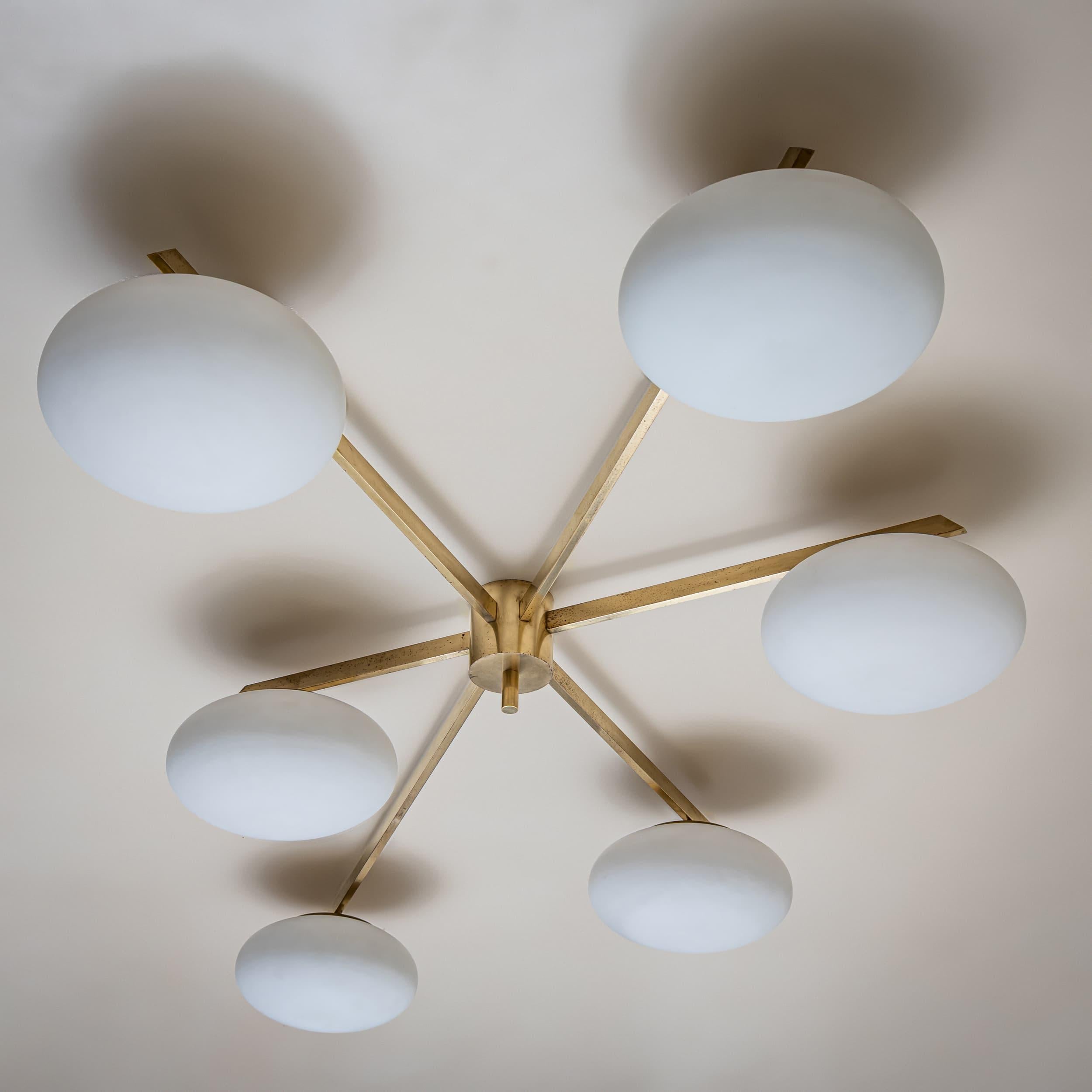 Ceiling lamp in brass and glass by Italian designer and founder of “Arredoluce” Angelo Lelli (1911–1979). The asymmetrical design features six slightly flattened globular shades in opaque glass. The brass has been lightly cleaned while preserving