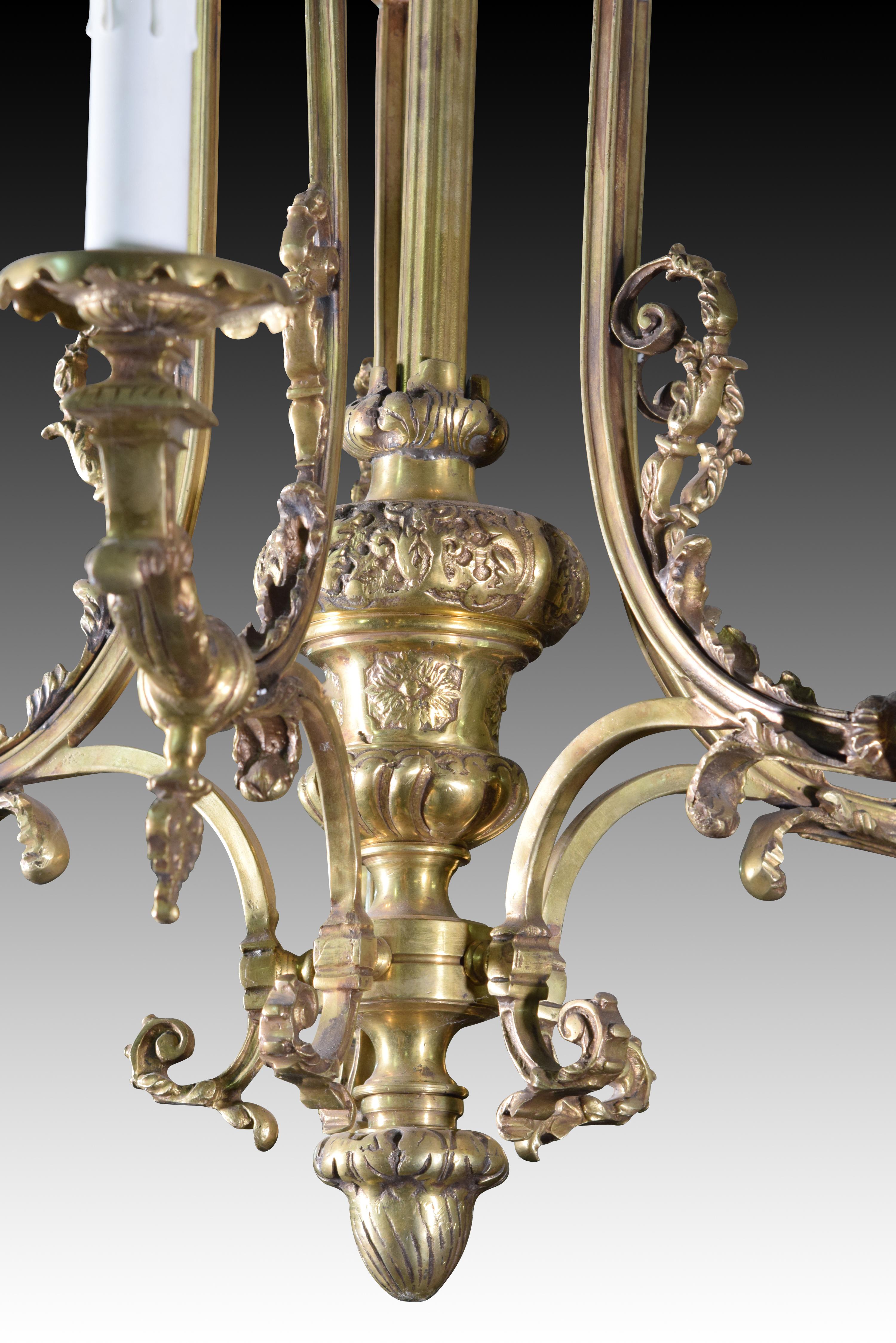 Ceiling lamp with six lights. Bronze with antique finish and glass.
 The central stem is decorated with vases, veneered shapes and vegetal scrolls. From its upper part emerge several buttons decorated with ovals from which stems curved with scrolls