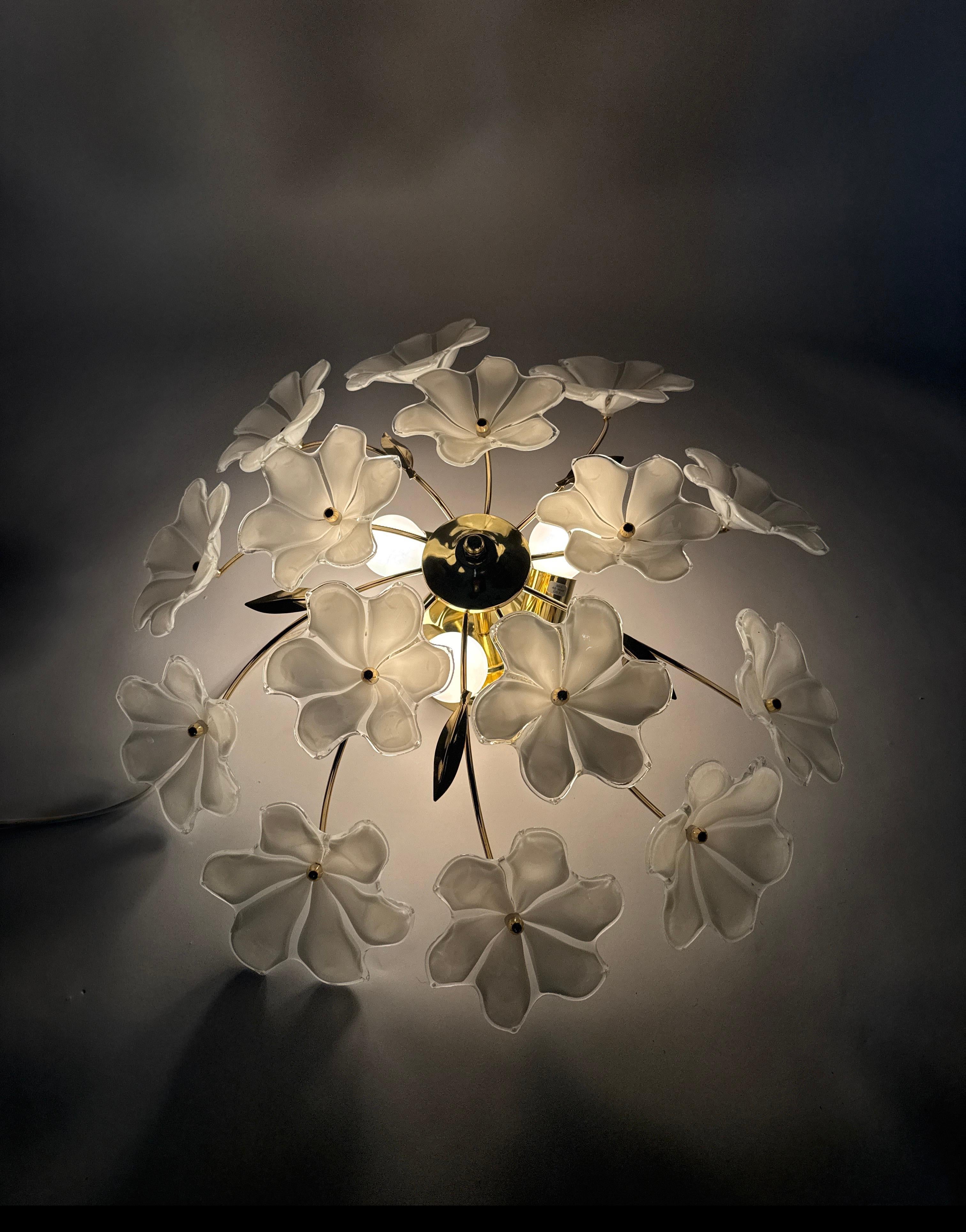 I bellissimi ed eleganti fiori bianchi in vetro di Murano rendono questa plafoniera così speciale. Questo lampadario è stato realizzato in Germania dall'azienda Honsel. La luce di questo lampadario è molto piacevole, il design è giocoso, attento e