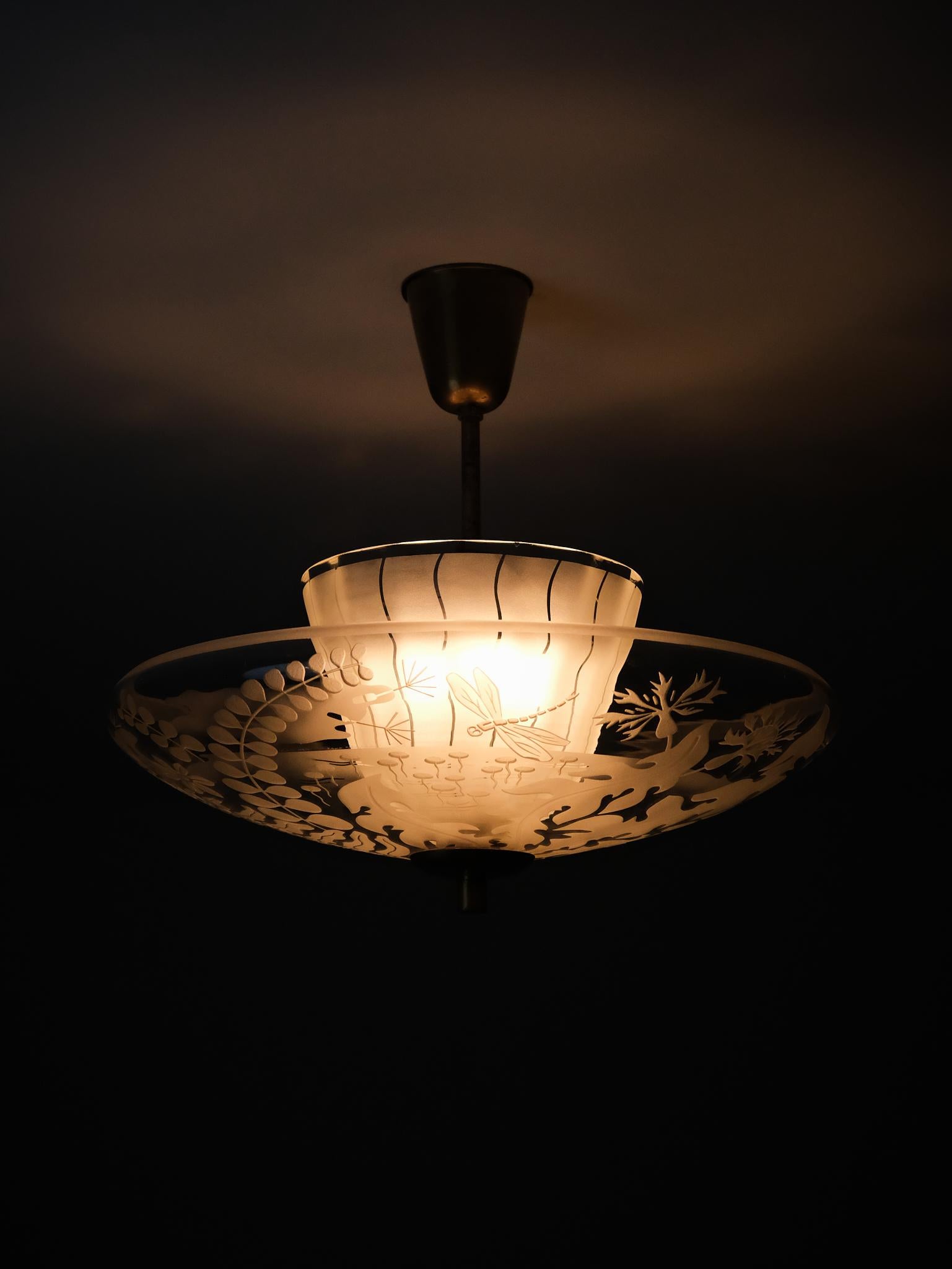 Una rara y elegante lámpara de techo diseñada por Bo Notini para Glössner & Co en Suecia durante la década de 1940.

Esta pieza presenta una pantalla de cristal esmerilado en dos partes montada sobre un tallo de latón, con exquisitos motivos