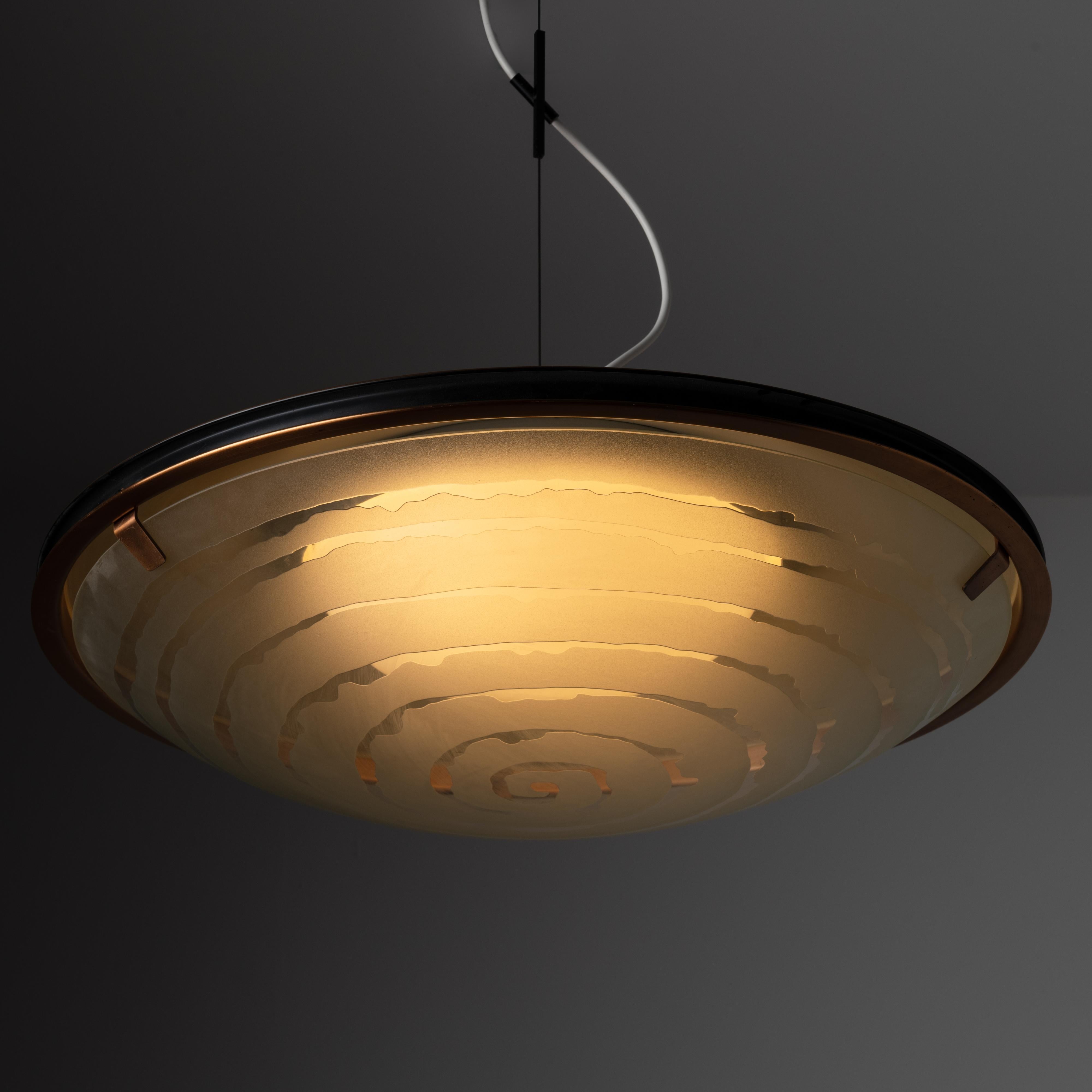 Ceiling light by Gaetano Sciolari for Stilnovo. Designed and manufactured in Italy, circa 1950. Aluminum frame with anodized copper finish, featuring a unique etched spiral within the frosted glass shade that encloses an opaline white diffuser