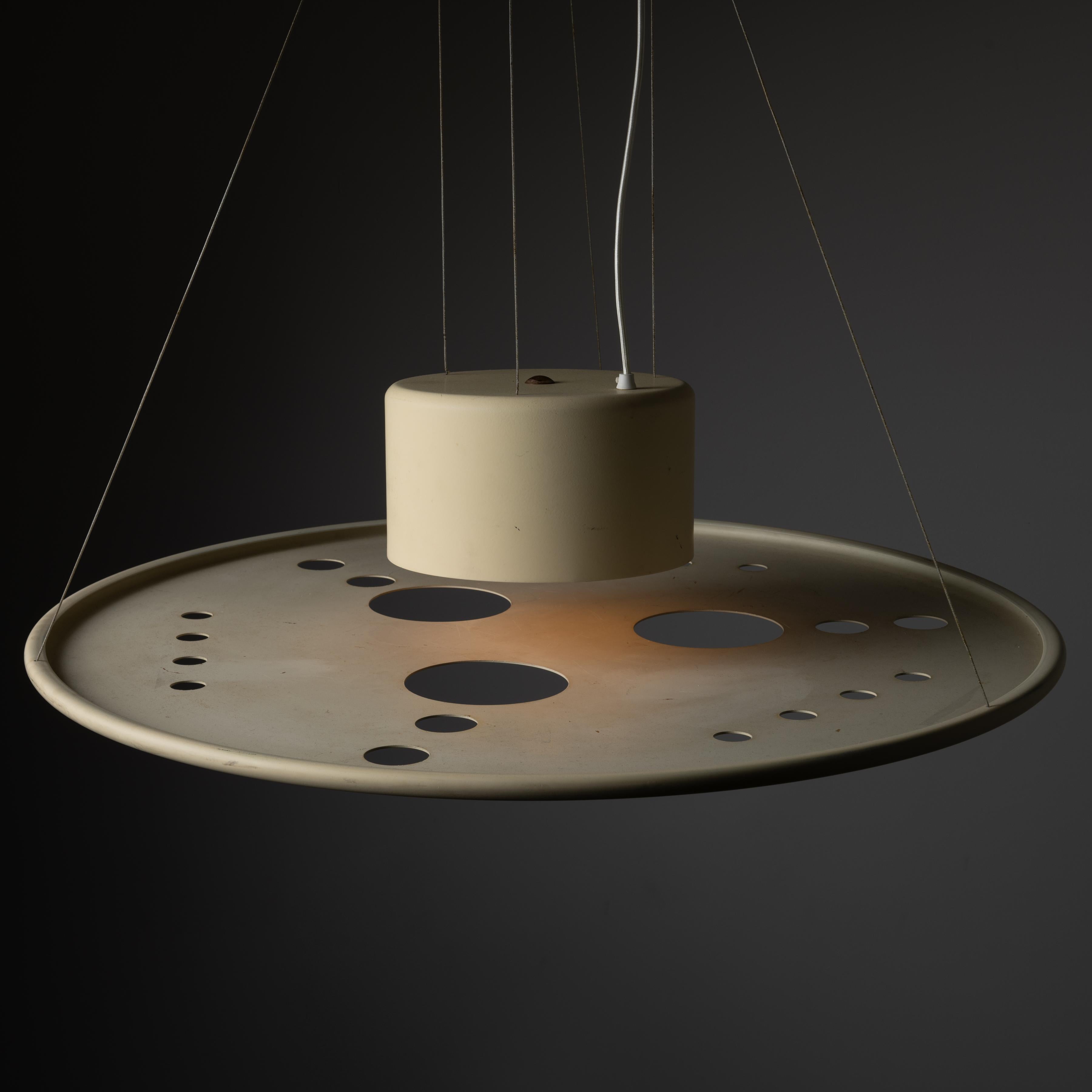 Rare Pendant by Giovanni Corradini and Giancarlo Simonetti. Designed and manufactured in Italy circa 1950s. Timeless and minimal ceiling light with suspended metal shade in an enameled cream that features abstracted circular die cuts providing an