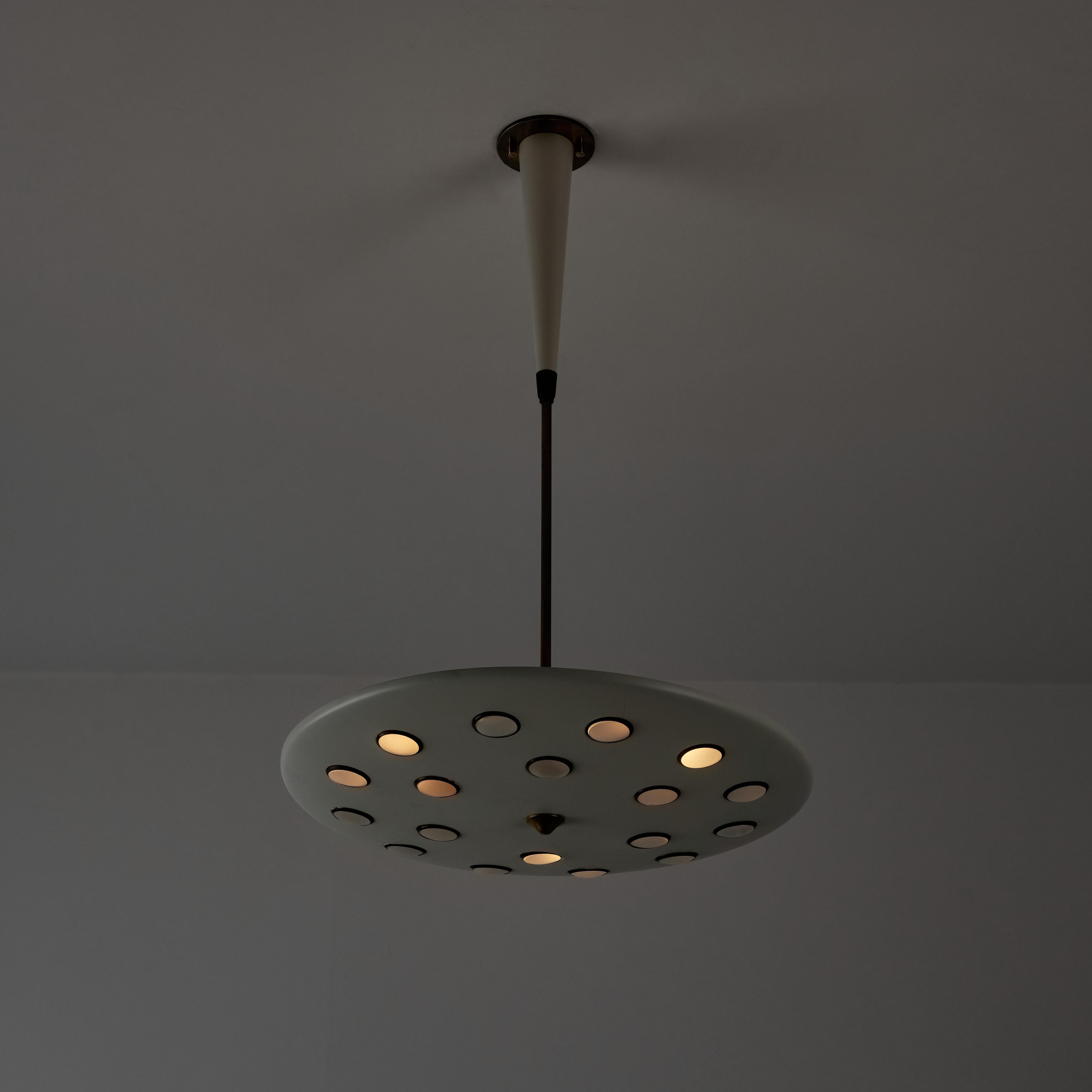 Ceiling light by Lumen. Designed and manufactured in Italy circa the 1950s. A beautifully refined featuring poked holes in the enameled dish. Each hole is rimmed by a brass ring, then nestled in the hole is a clear lens. The light holds a tri-socket