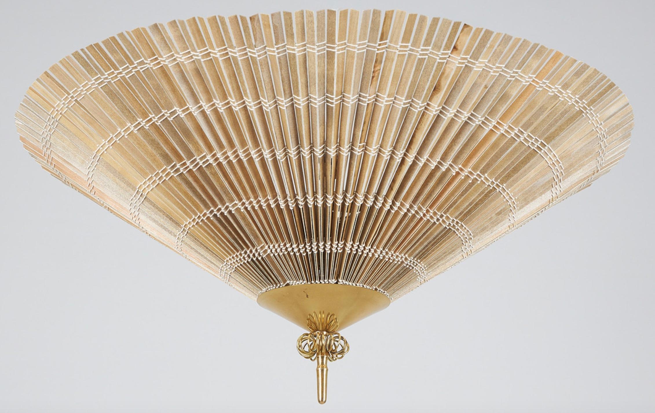A ceiling light designed by Paavo Tynell for Idman, Model K5-34. Finland , circa 1950th.

Polished brass with wooden slots shade. (3) lamp sockets. Diameter 25.6″, height approx. 12″.

Existing wires, rewiring available upon request.
