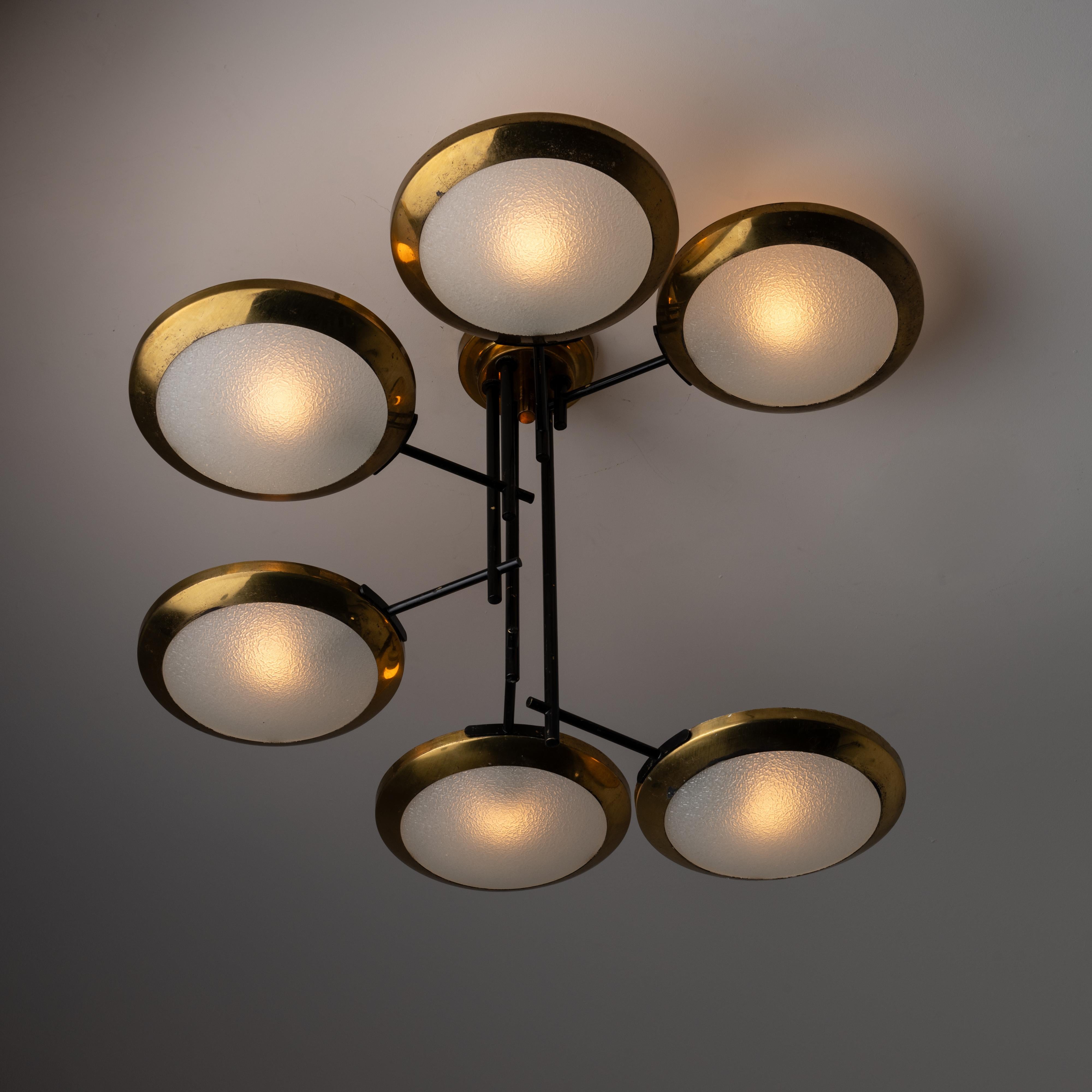 Ceiling Light by Stilnovo. Designed and manufactured in Italy, circa the 1950s. Six shade chandelier consisting of circular rings cascading down a multi stem. Each ring is made up of polished brass, enameled steel and a textured glass diffuser. Each