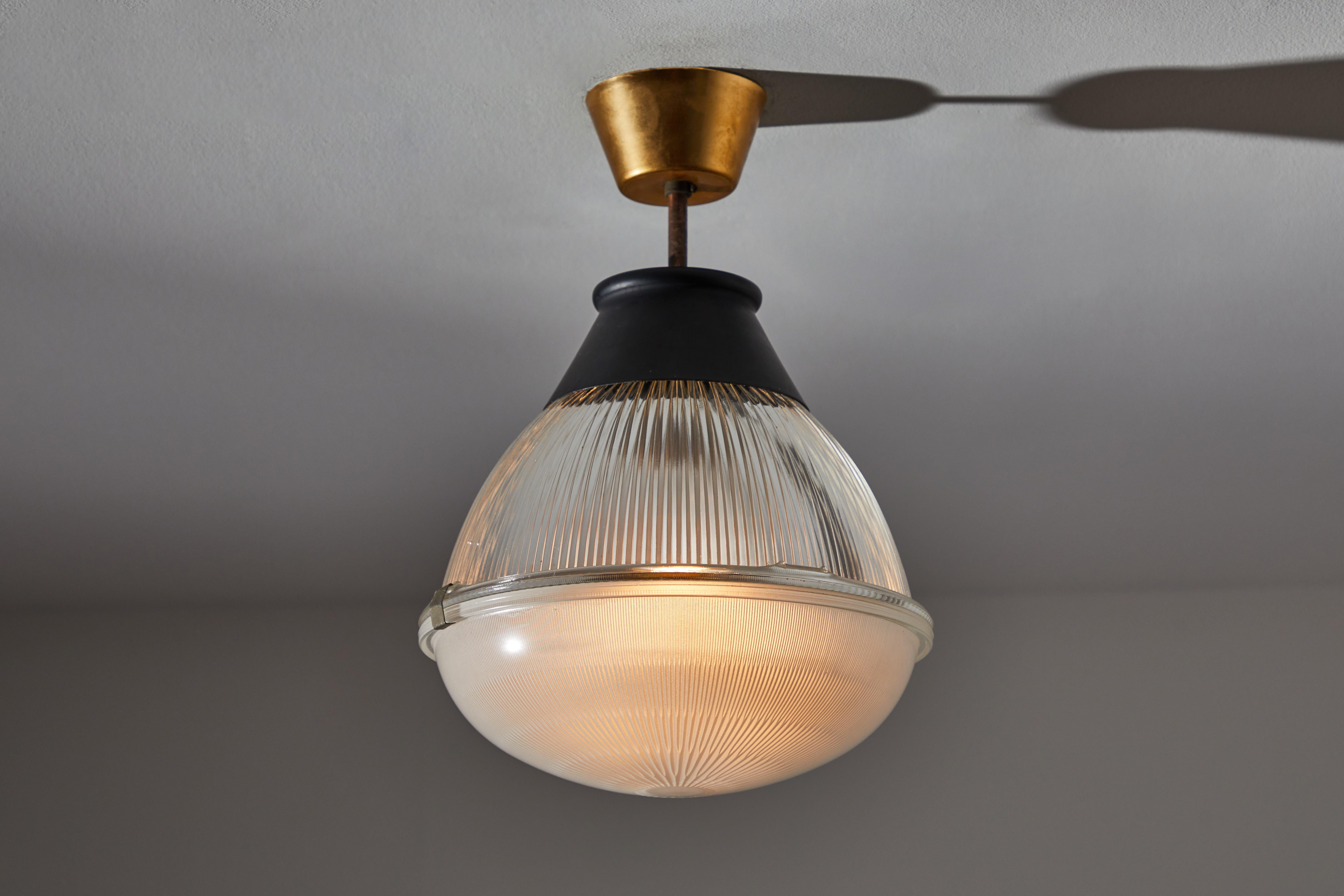 Ceiling light by Tito Agnoli for Oluce. Designed and manufactured in Italy, 1958. Holophane glass diffuser, original brass canopy. Wired for US standards. We recommend one E27 100w maximum bulbs. Bulbs provided as a one time courtesy.